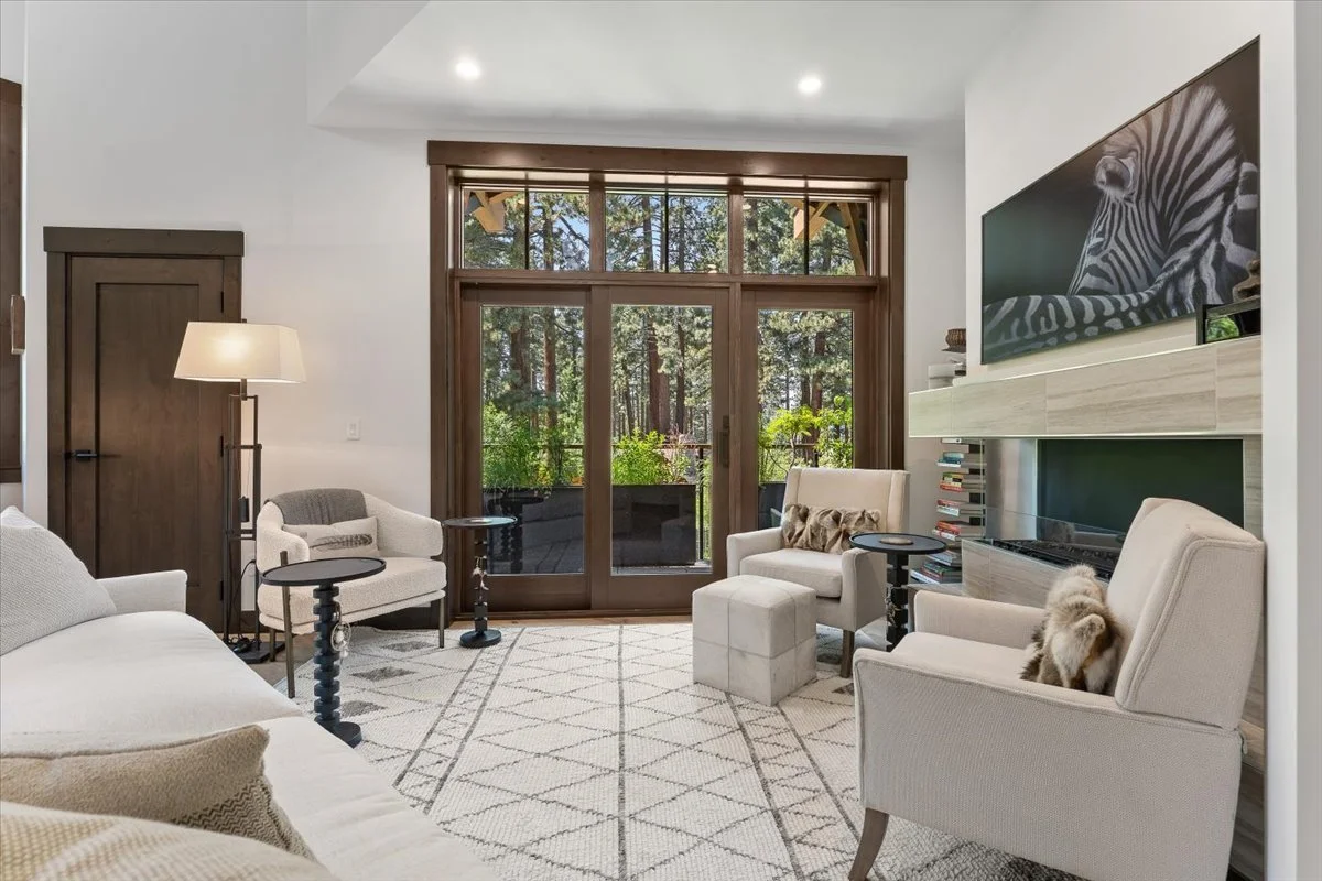 Open-concept living room with radiant heated floors, forest views, and an EcoSmart fireplace. Wide walkways and elevator access make this space comfortable and ADA-friendly. Natural light and peak-a-boo lake views offer a serene mountain retreat.