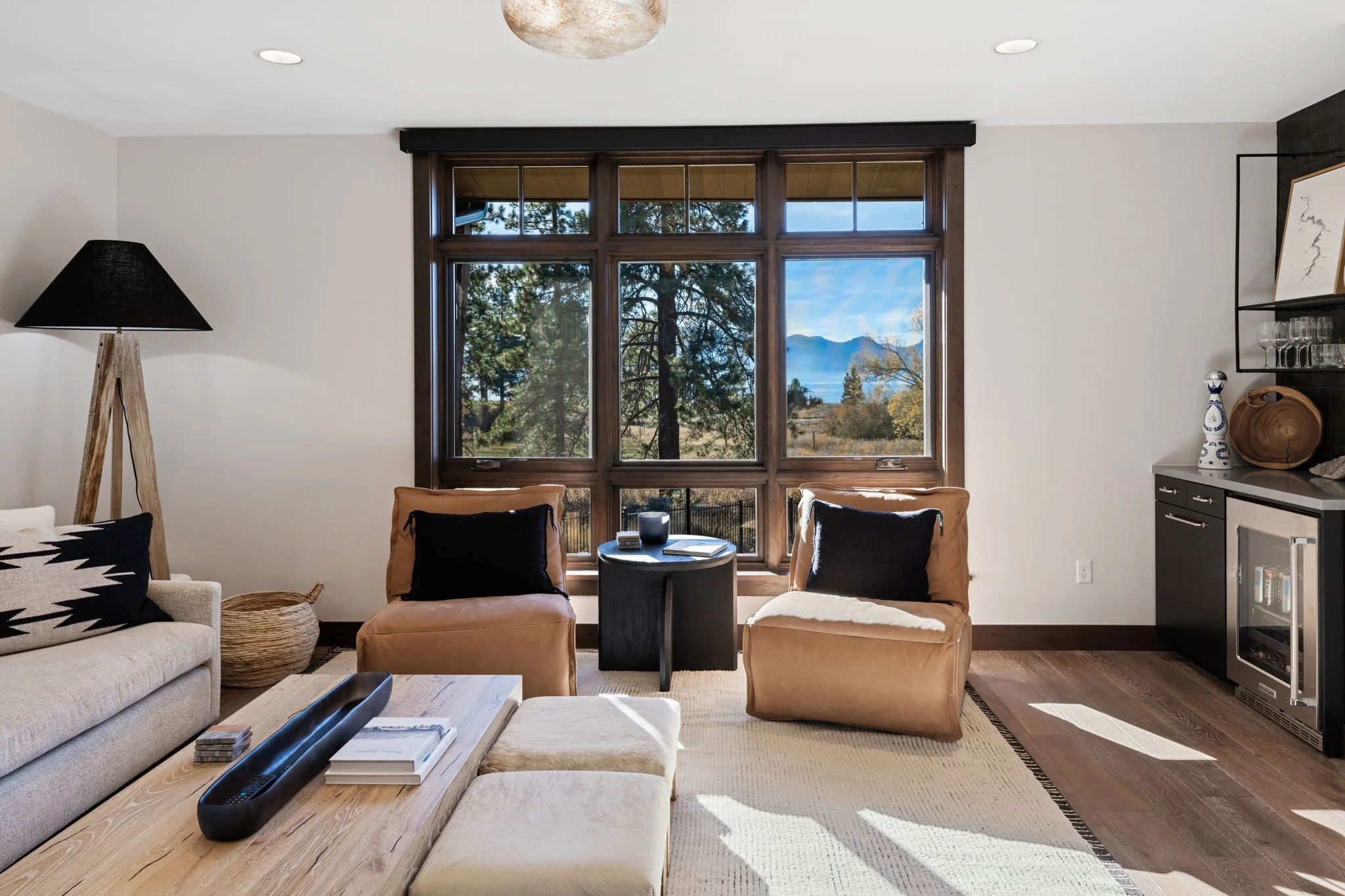 Residence 215 features an open-concept floor plan with a bright living room, cozy fireplace, and hardwood flooring throughout. A glass door opens to a private patio, creating seamless indoor-outdoor living and inviting natural light into the space.