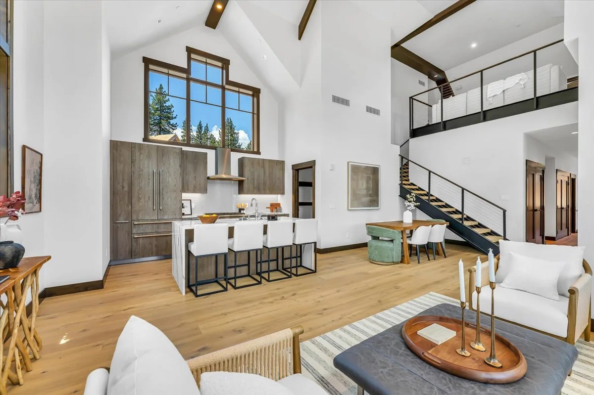 Bright and airy Tahoe Beach Club great room showcasing vaulted ceilings, modern finishes, wide-plank hardwood floors, and a spacious loft overlooking the open-concept living and dining areas.