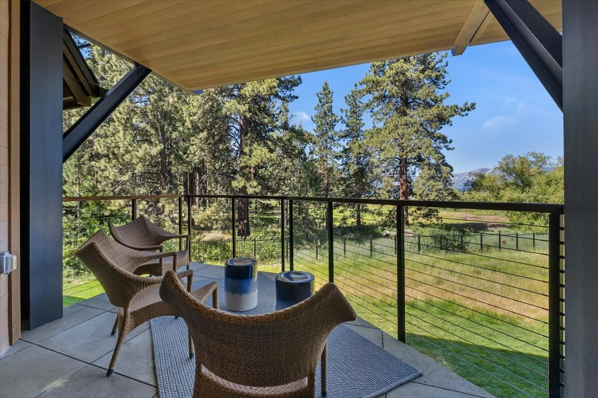 This covered and private patio offers stunning views of the lake, meadow, forest and mountains, providing the perfect setting for an elegant outdoor dining experience.