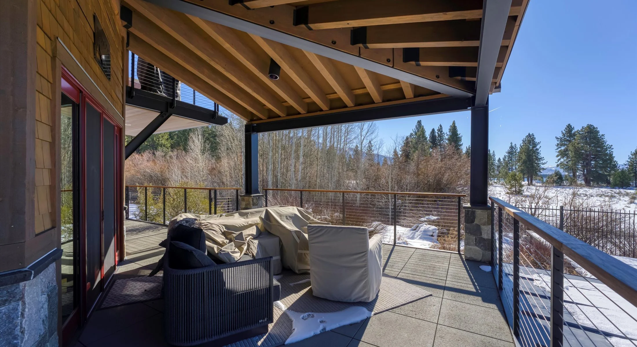 Relax in this serene covered patio, featuring  peaceful views of the surrounding trees, and the lake in the distance —perfect for enjoying quiet mornings or sunset evenings.