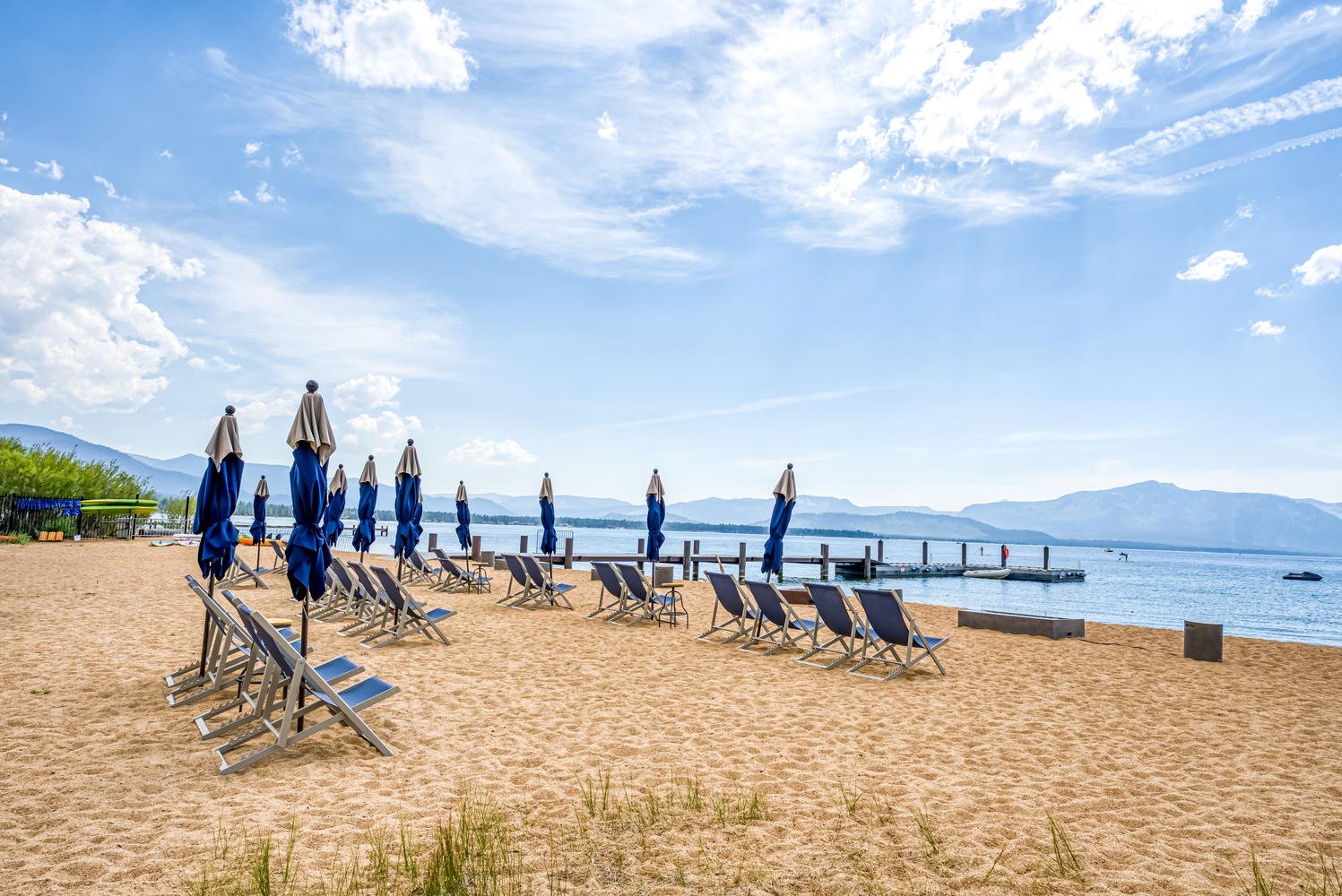 Tahoe Beach Club's private beach, where rows of beach chairs and vibrant umbrellas dot the sandy landscape.