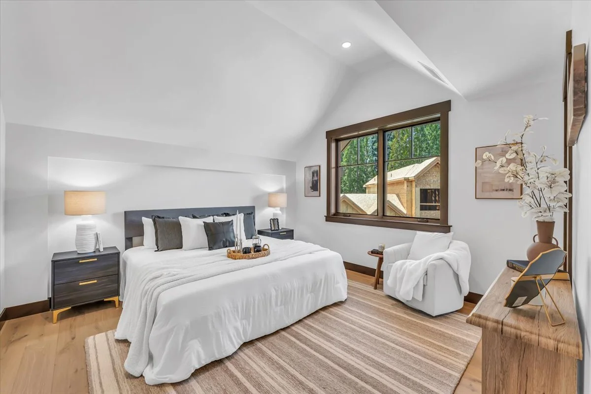 Bright and spacious bedroom at Tahoe Beach Club featuring wide-plank hardwood floors, large window with scenic views.