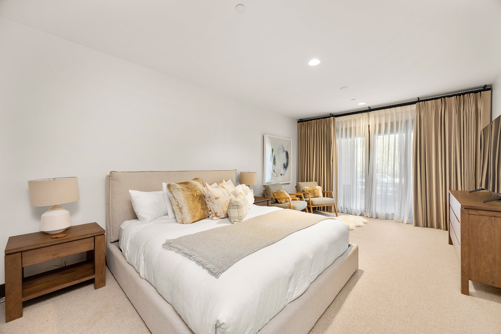 Residence 206's second comfortable bedroom featuring a big bed and a TV.