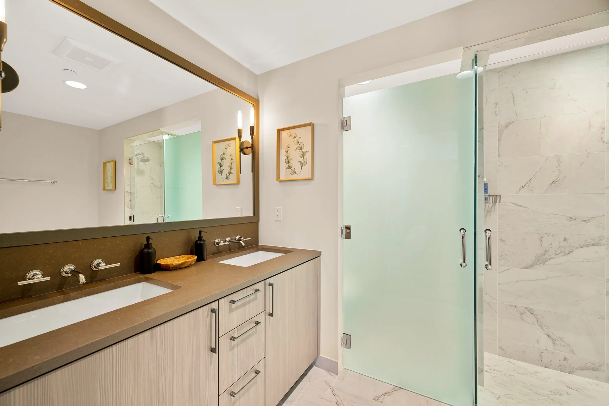 One of Residence 206's four modern bathrooms featuring a glass shower door and a stylish sink.