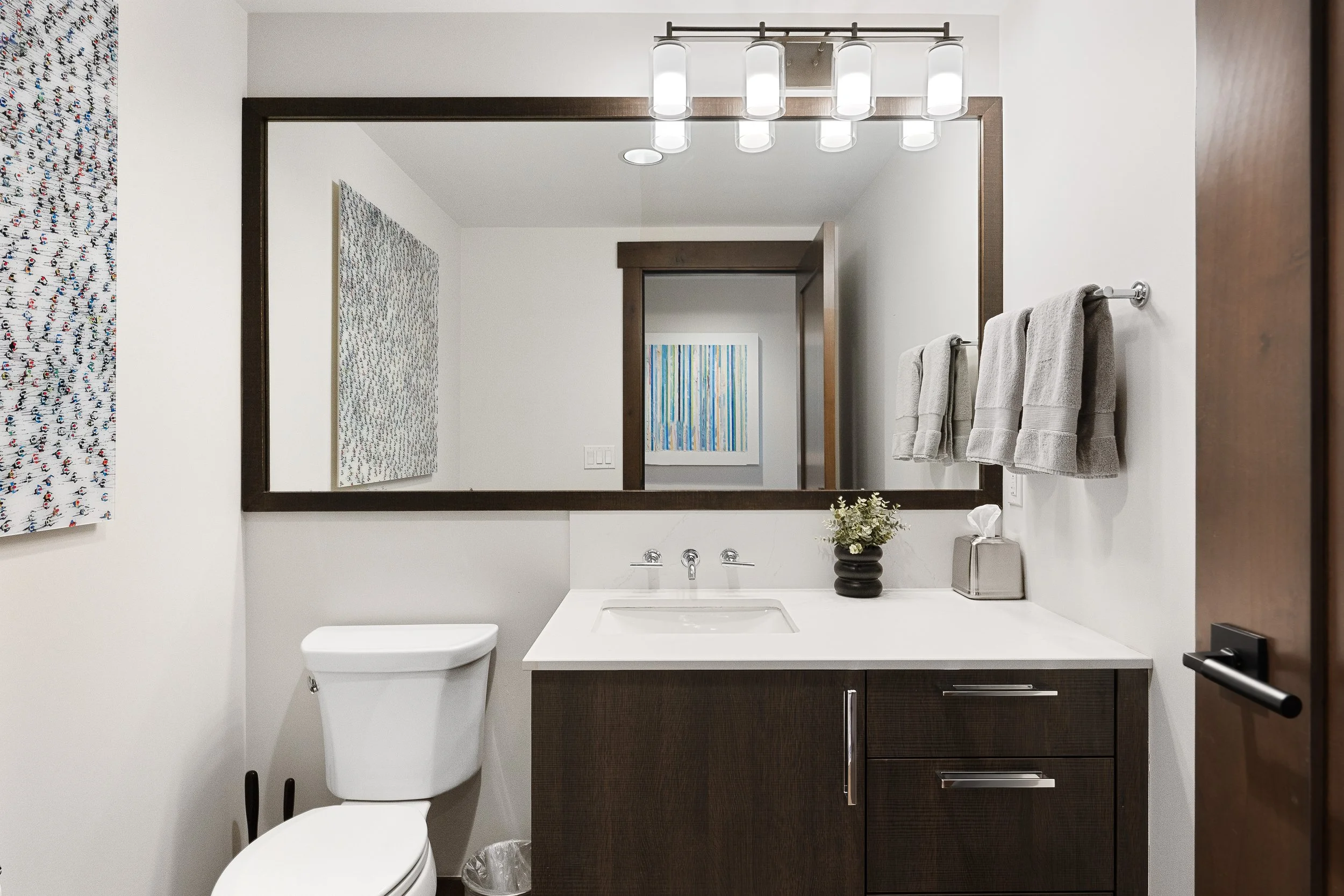 Elegant bathroom features a spacious vanity with modern cabinetry and a large mirror further enhance the room's refined aesthetic.