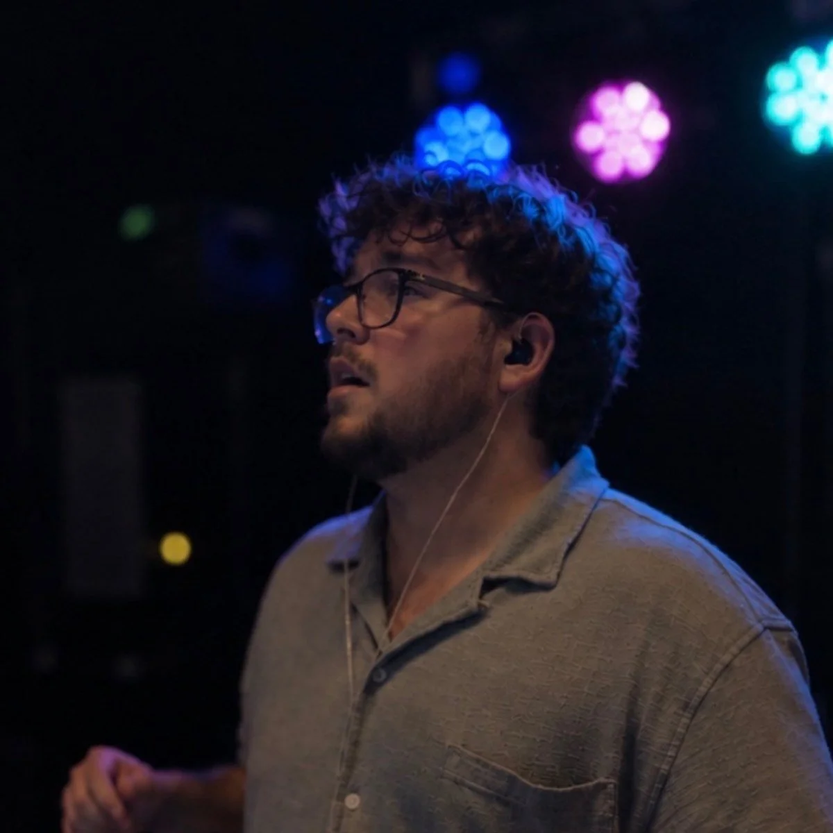 Nick Bailey of Epiphany Gulf Coast DJing at the decks under colored lights
