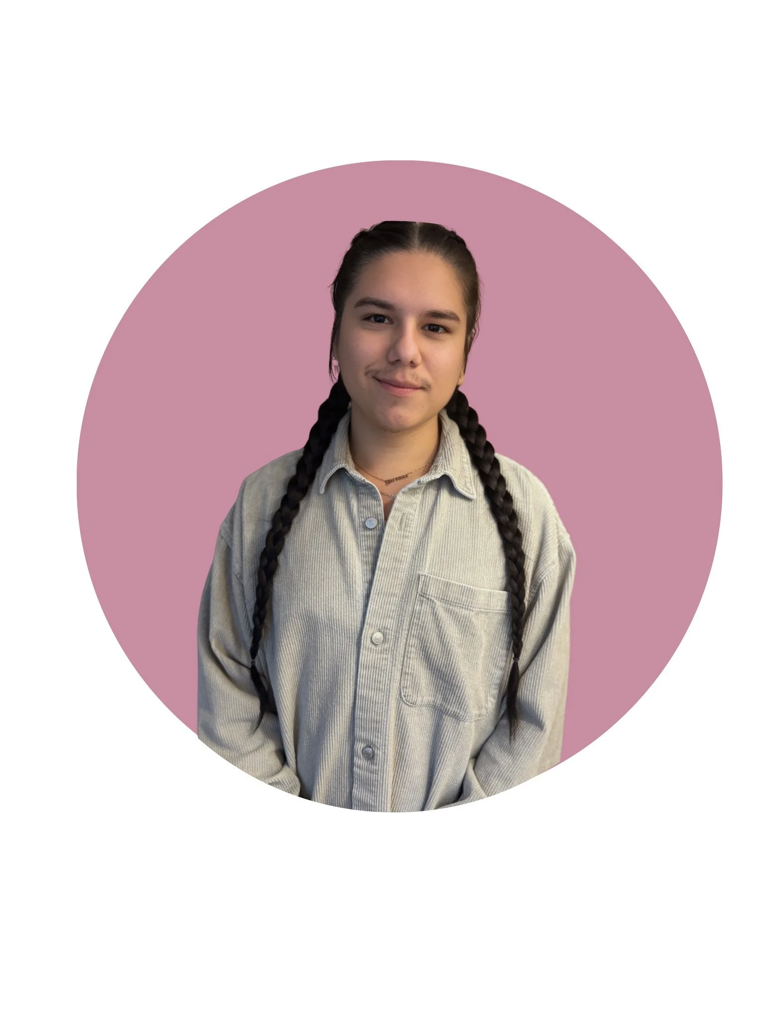 A young person with long dark hair wearing a white shirt and a hat, standing indoors in front of a yellow wall and door.