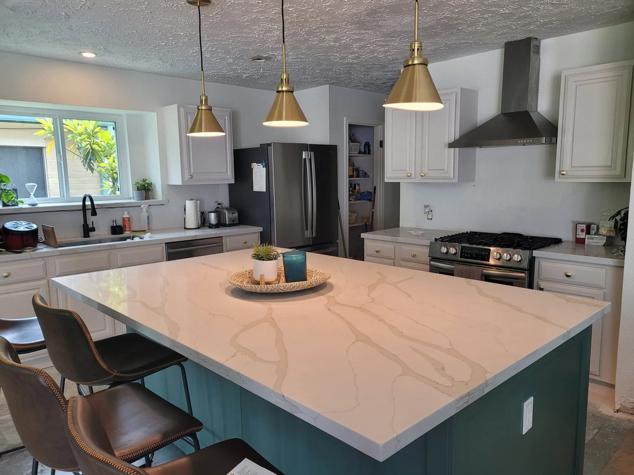 Medium-sized kitchen with white cabinets and green accent island painted in Missouri City, Texas