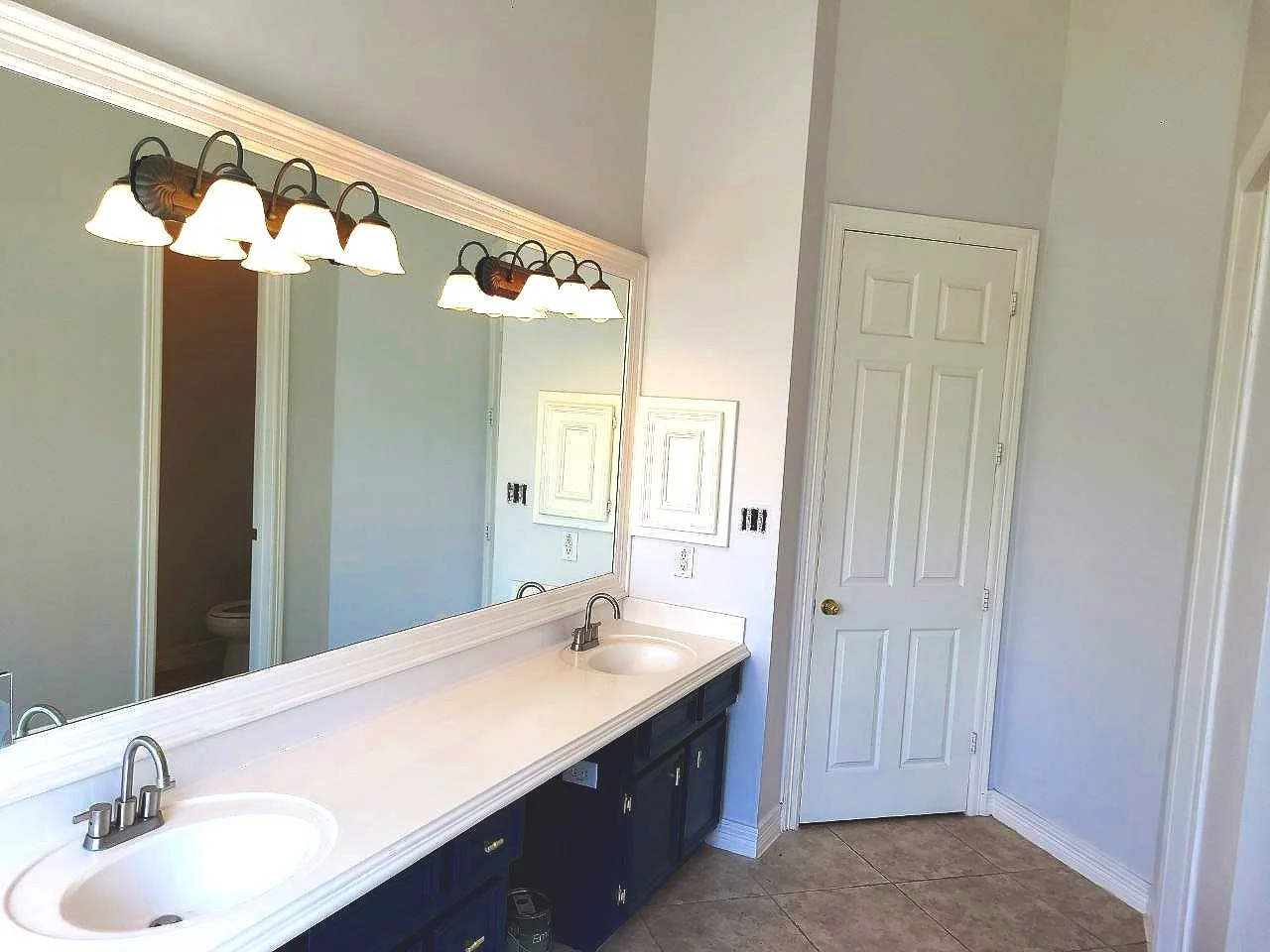 Freshly painted navy blue vanity with off-white walls and trim in a Sugar Land, Texas bathroom