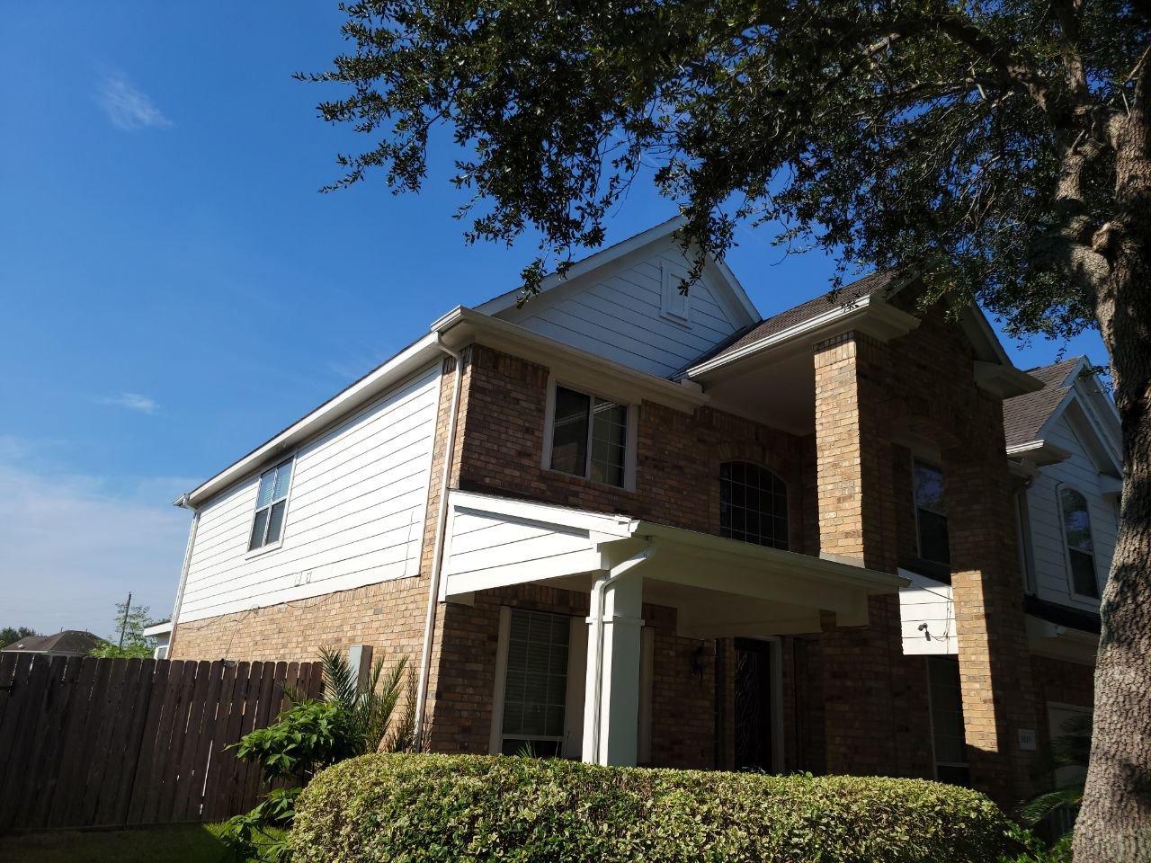 Freshly painted medium-sized two-story home exterior in Texas by professional painters.