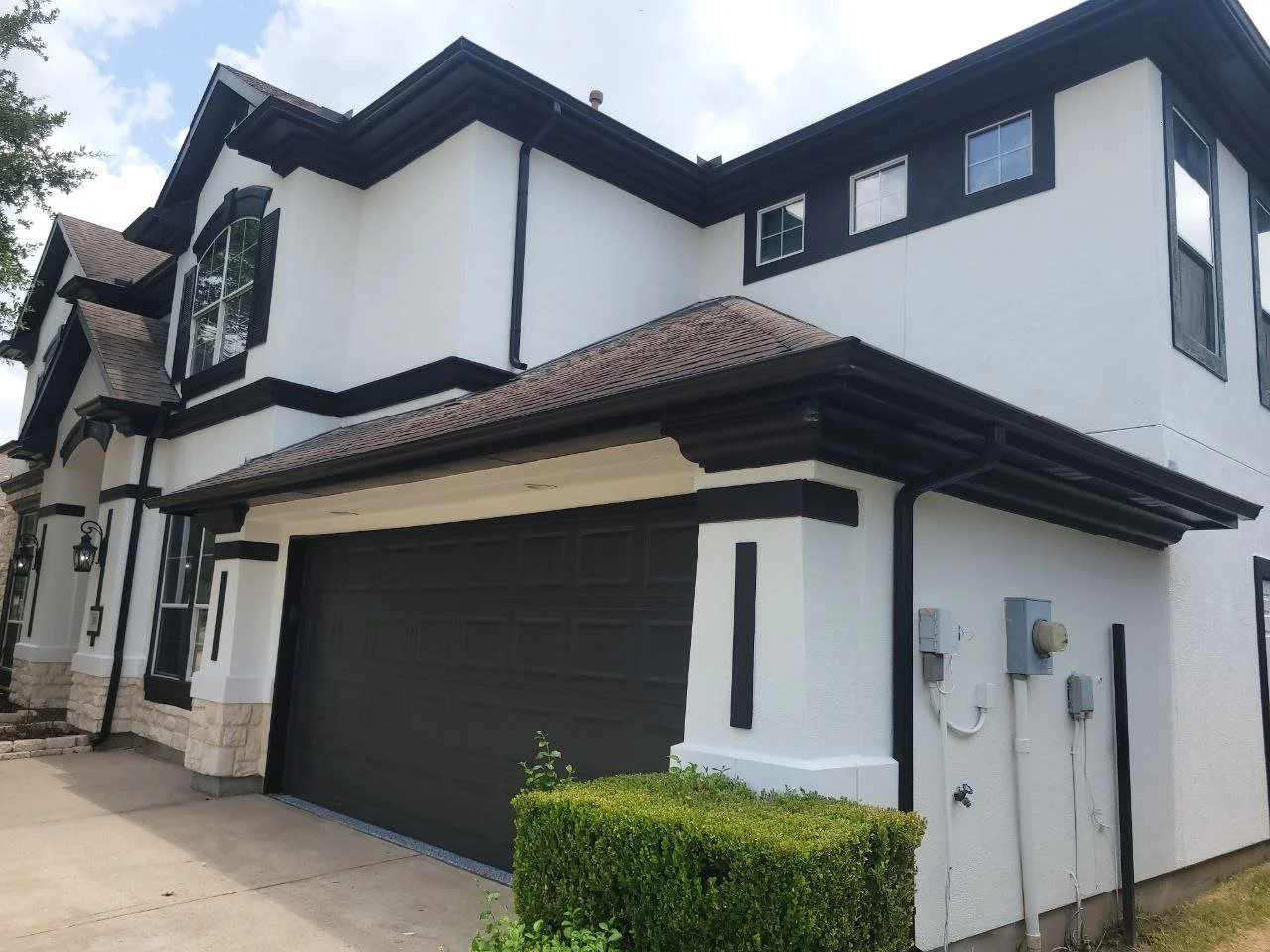 Freshly painted stucco house exterior with garage door and shutters in Sugar Land, Texas.