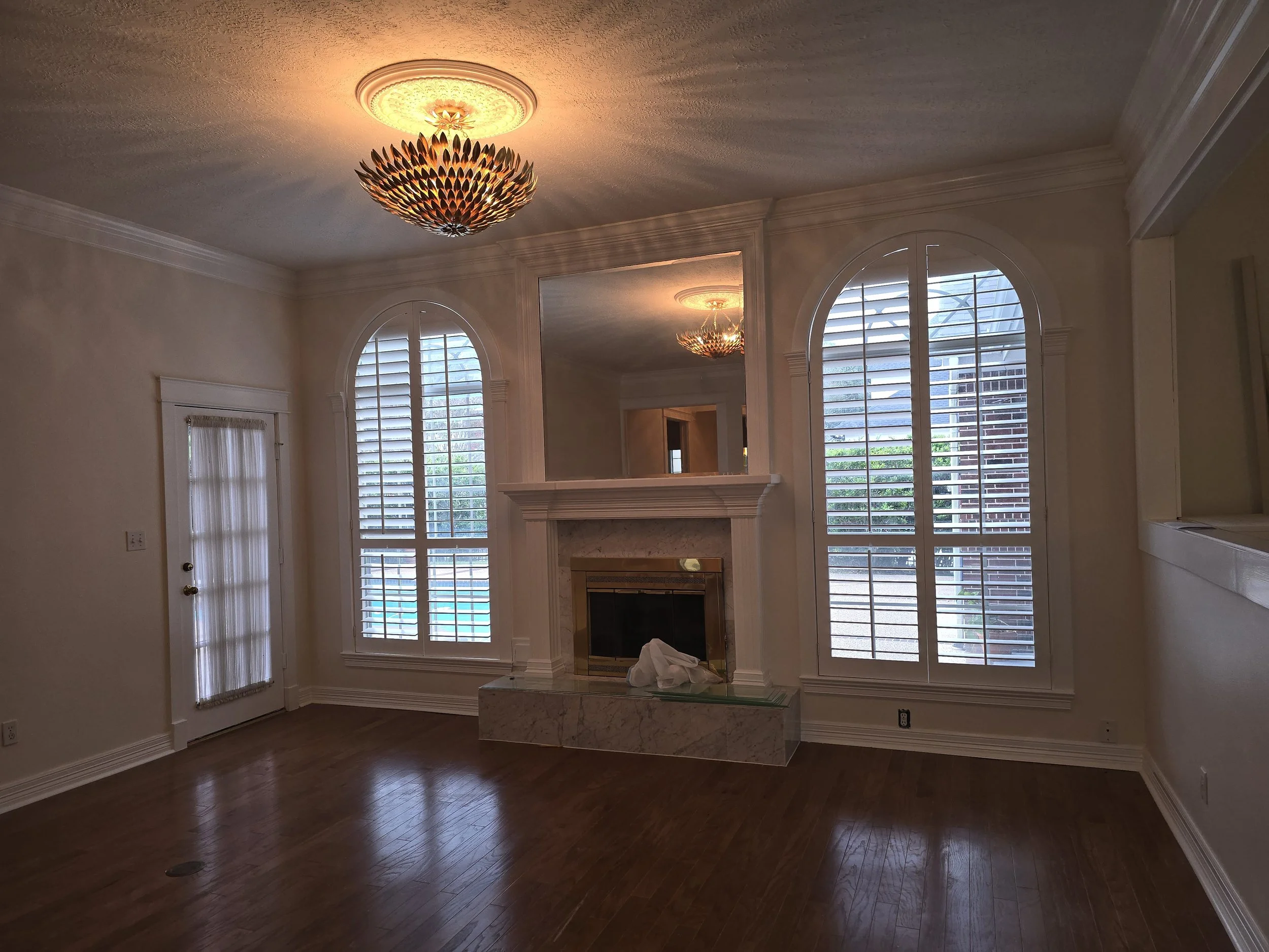Elegant living room with high ceilings and freshly painted walls in Sugar Land, TX interior painting project by The Proud Paintbrush.