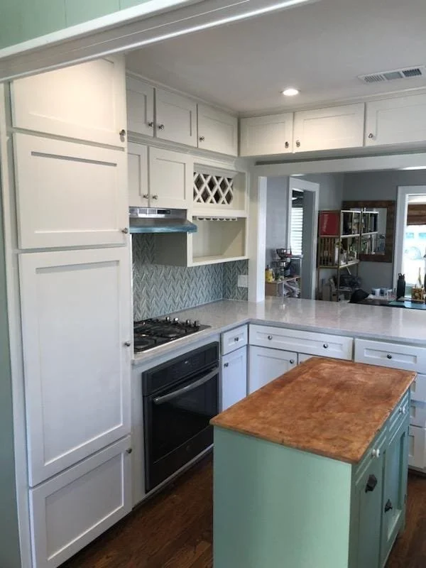 Freshly painted white kitchen cabinets with island in West Houston, TX cabinet painting project by The Proud Paintbrush.