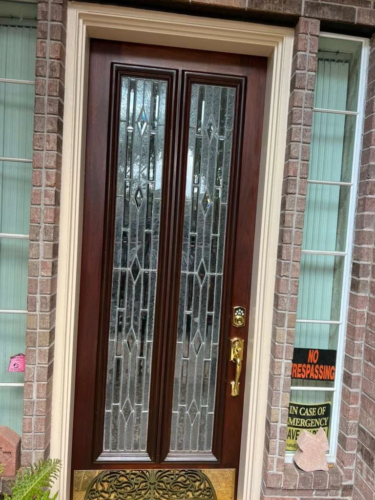 Freshly stained and refinished front door in red mahogany color in Sugar Land, Texas.