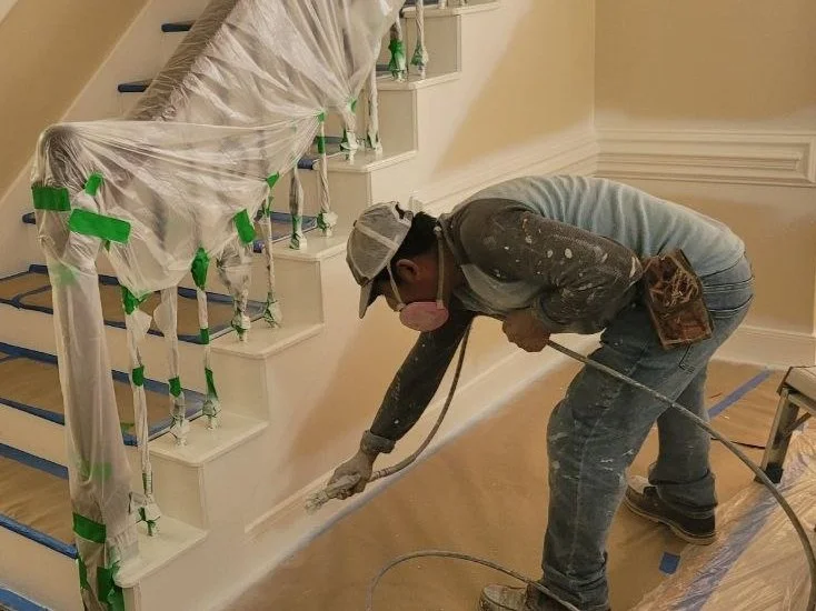 Professional painter spraying interior trim for a smooth finish in a home in Katy, Texas