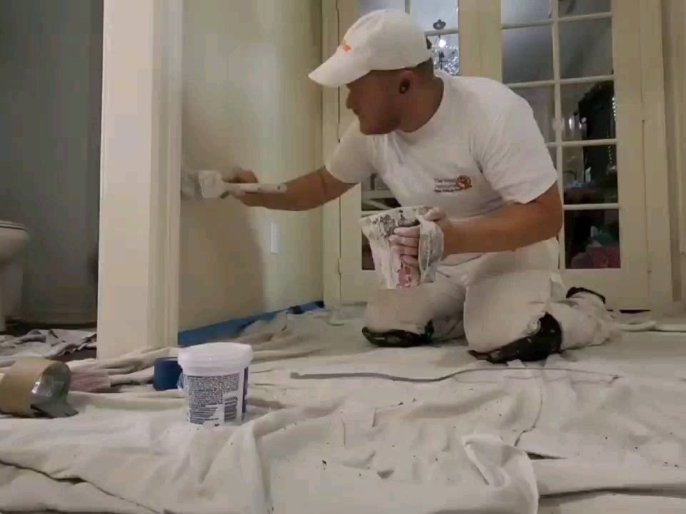 Professional painter carefully cutting in trim during interior painting in Fulshear, Texas.