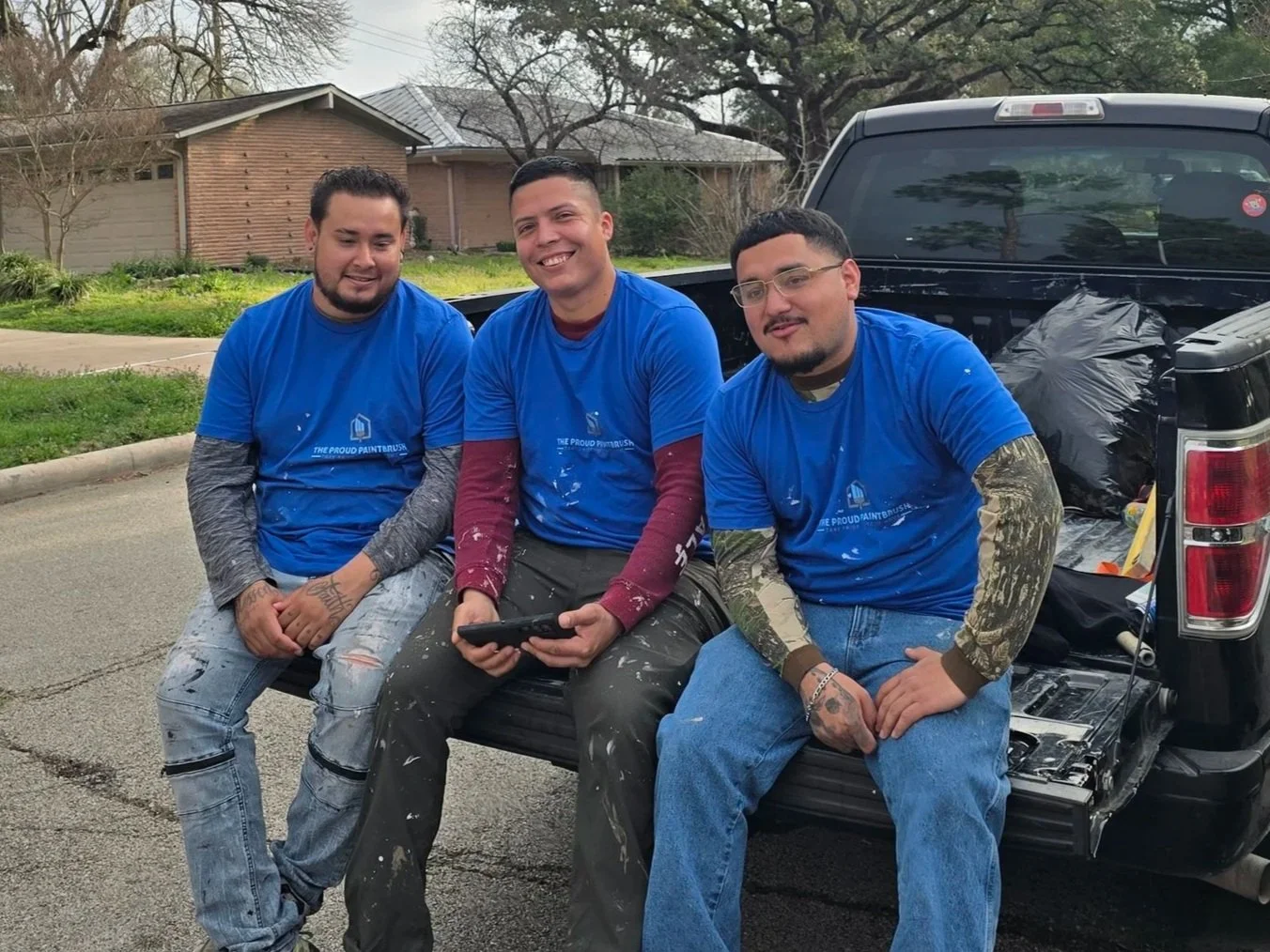 Three professional painters taking a lunch break during a residential painting project in West Houston, Texas