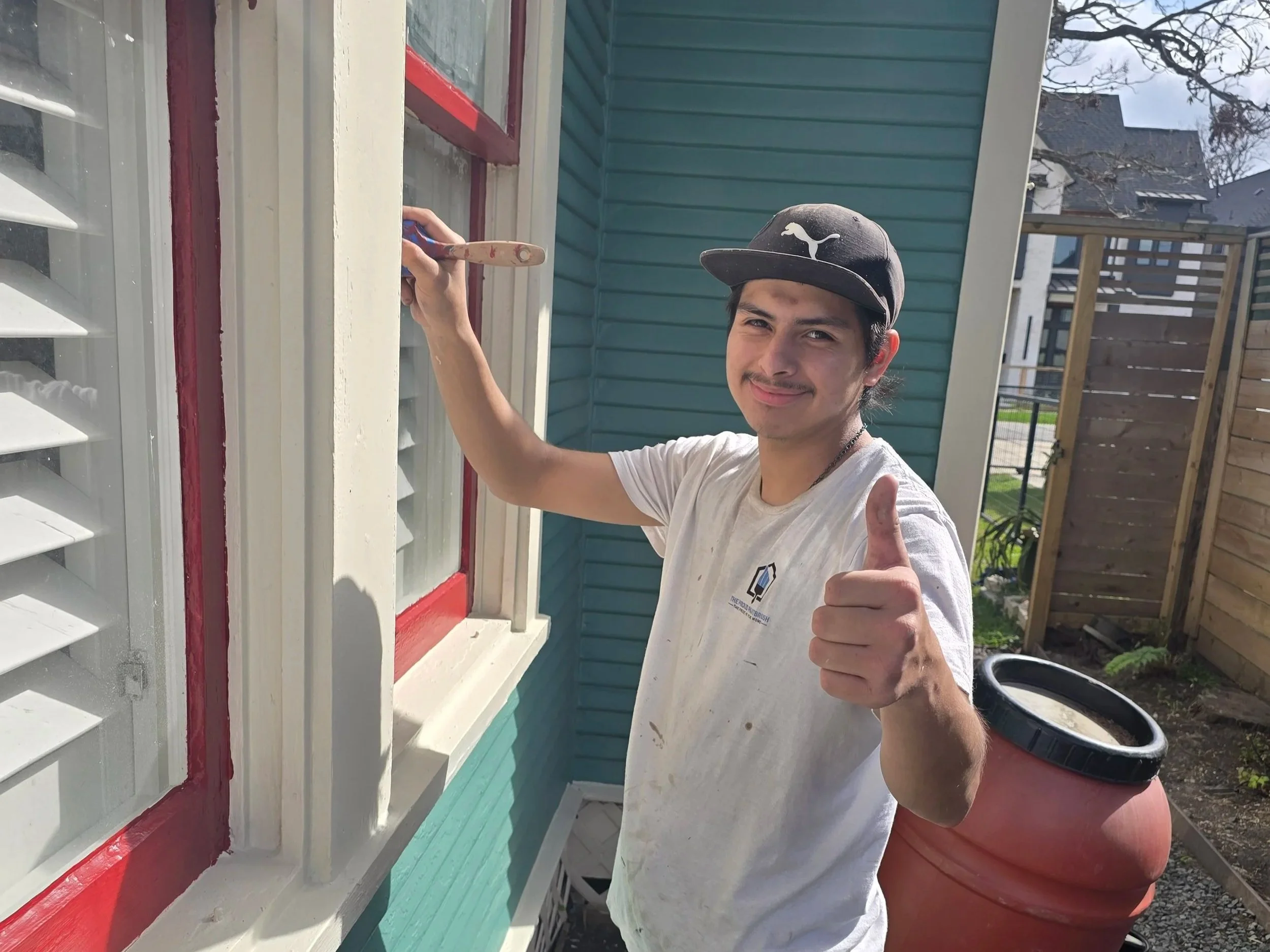 Professional painter performing exterior prep and trim painting on home in West Houston, TX for The Proud Paintbrush.