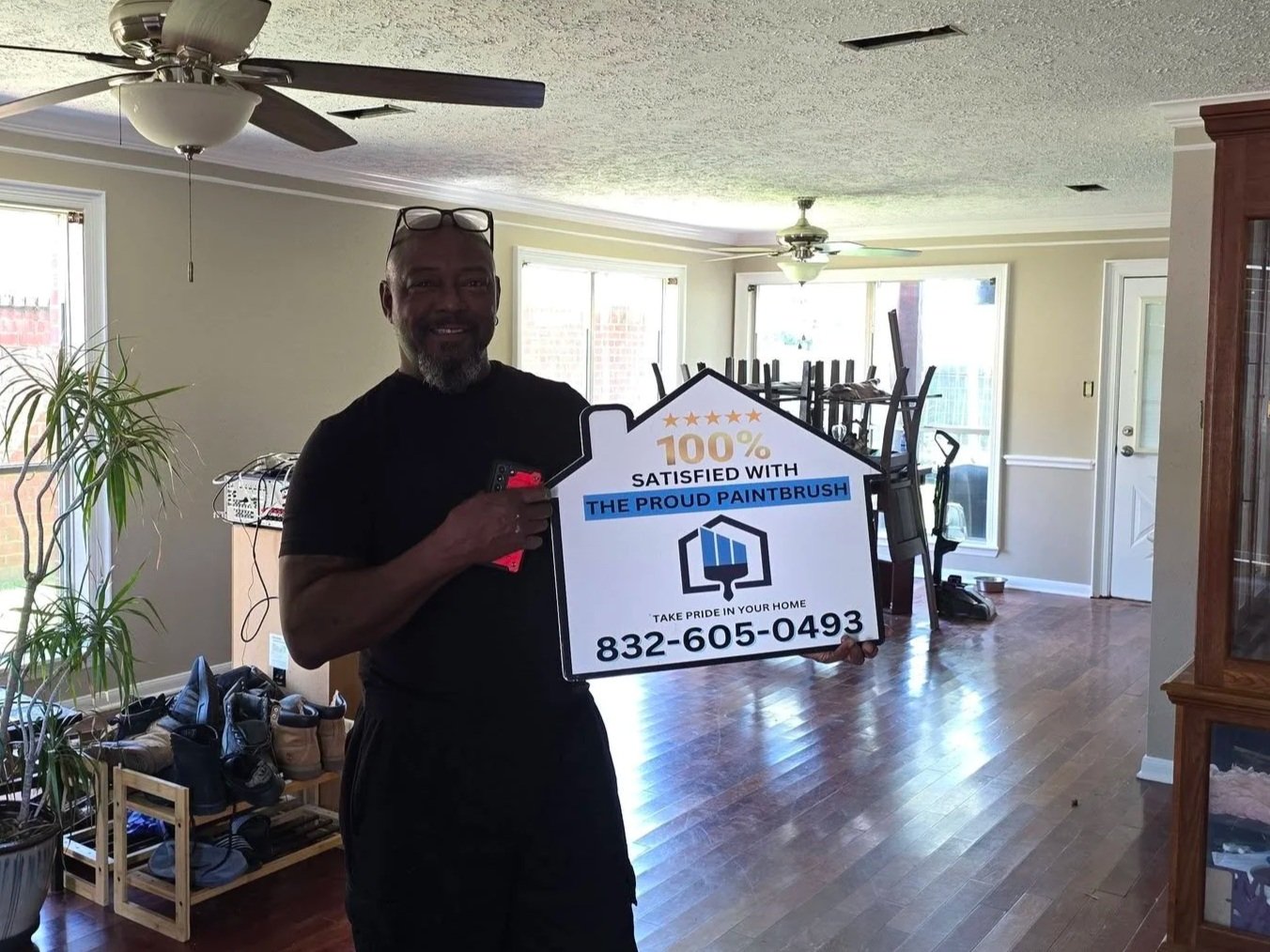 Happy homeowner standing in freshly painted home in Missouri City, TX after an interior painting project by The Proud Paintbrush.