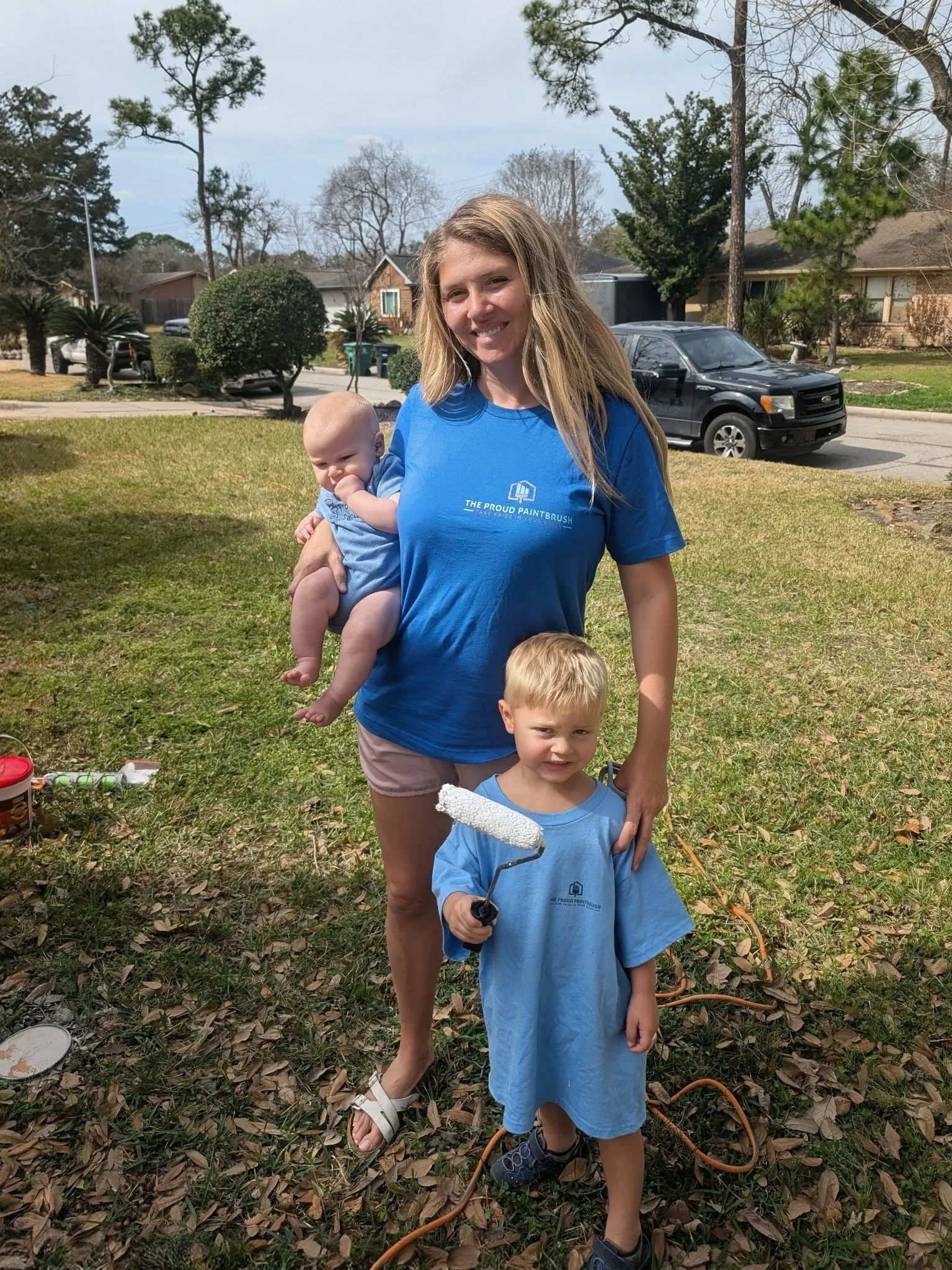 Sarah Petkau, wife of Chris Petkau, participating in Paint It Forward 2026 with her sons Isaac and Sammy in West Houston, Texas.