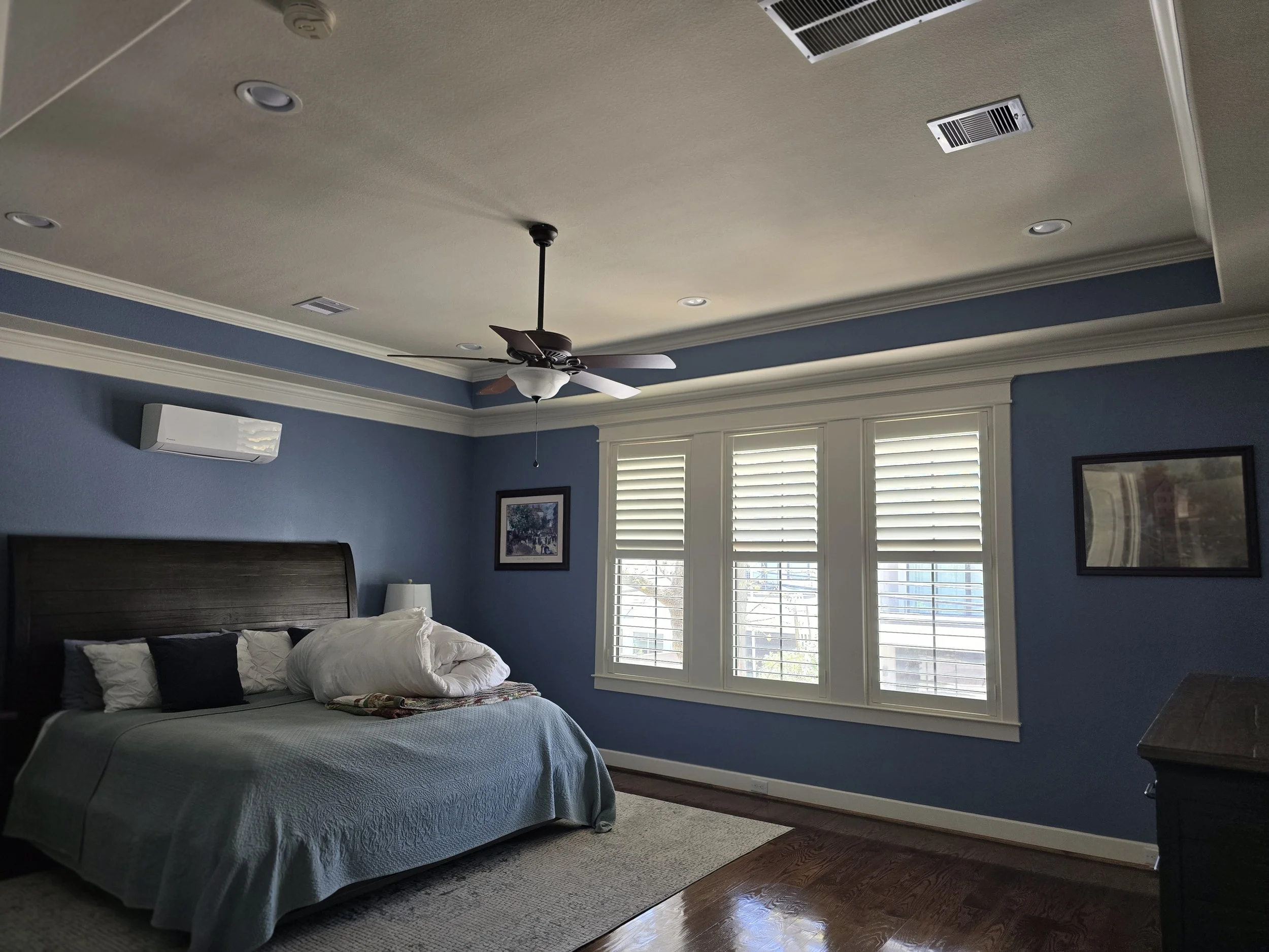 Freshly painted bedroom with dark blue walls and tray ceiling in Southwest Houston, TX interior painting project by The Proud Paintbrush.