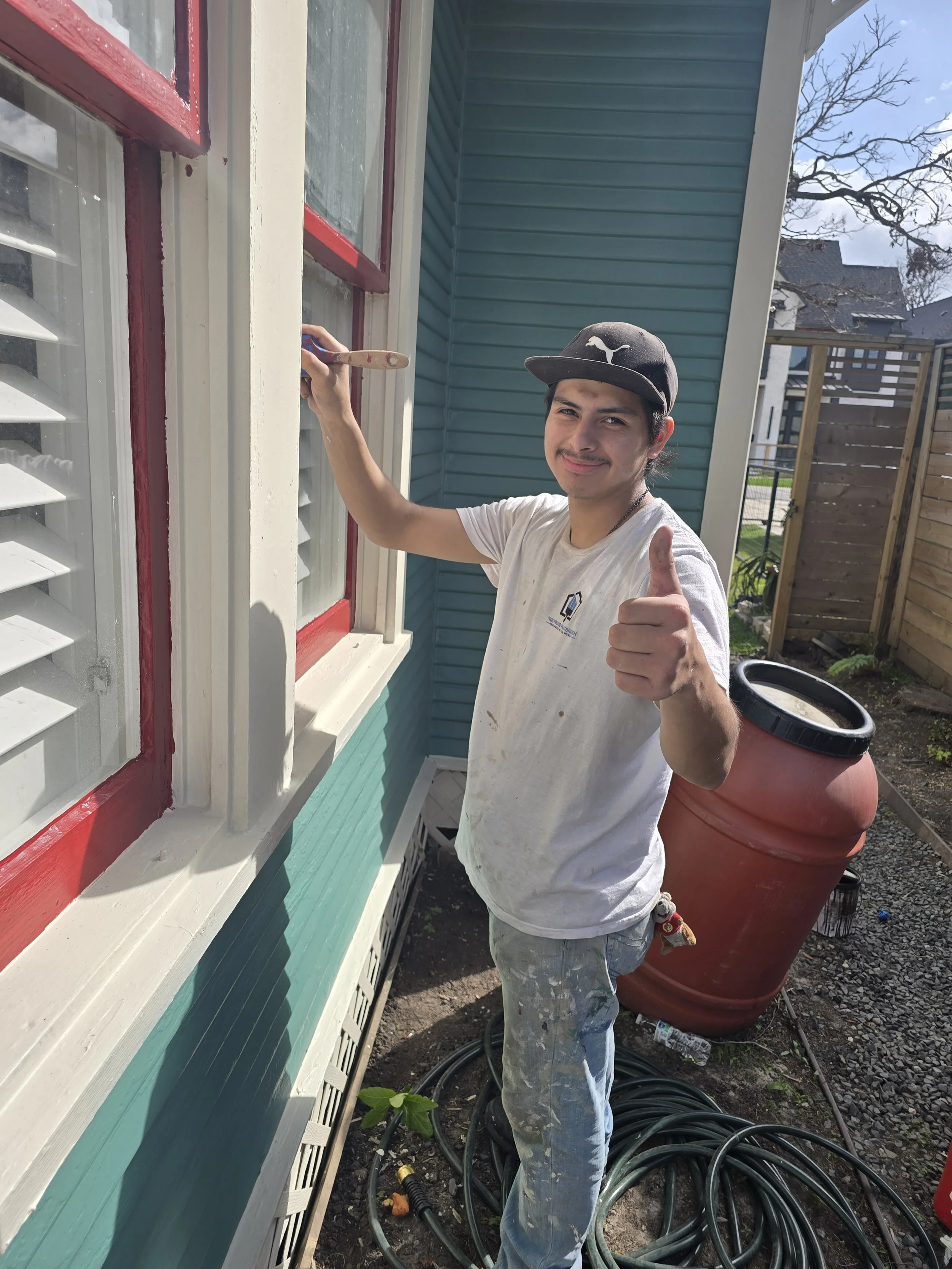 Professional painter performing exterior prep and trim painting on home in West Houston, TX for The Proud Paintbrush.