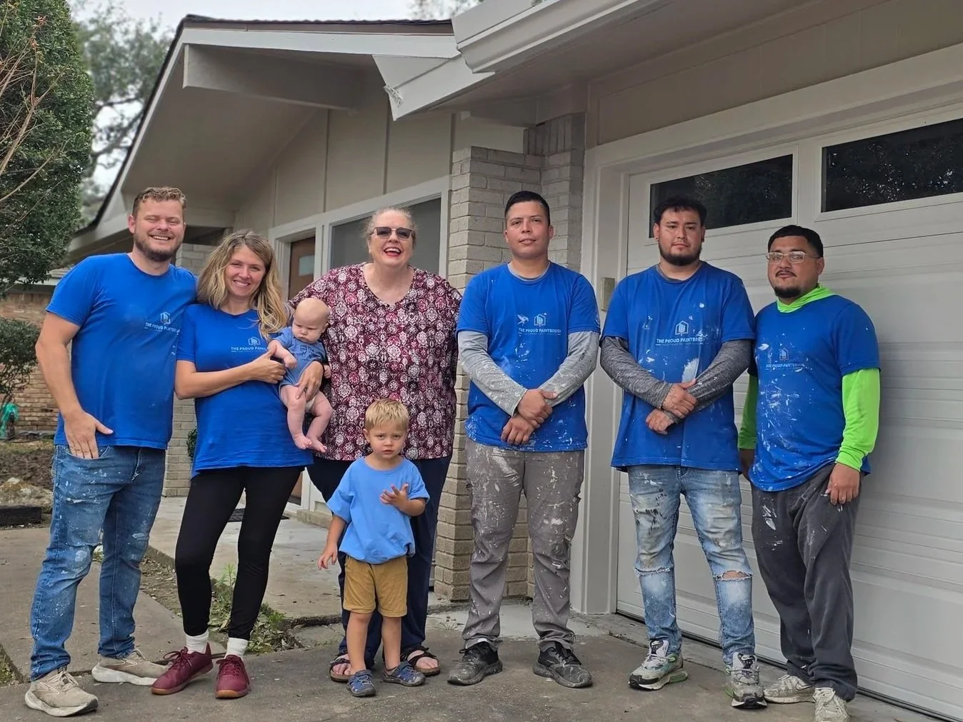 The Proud Paintbrush team and homeowners during a Paint It Forward community project in Sugar Land, TX.