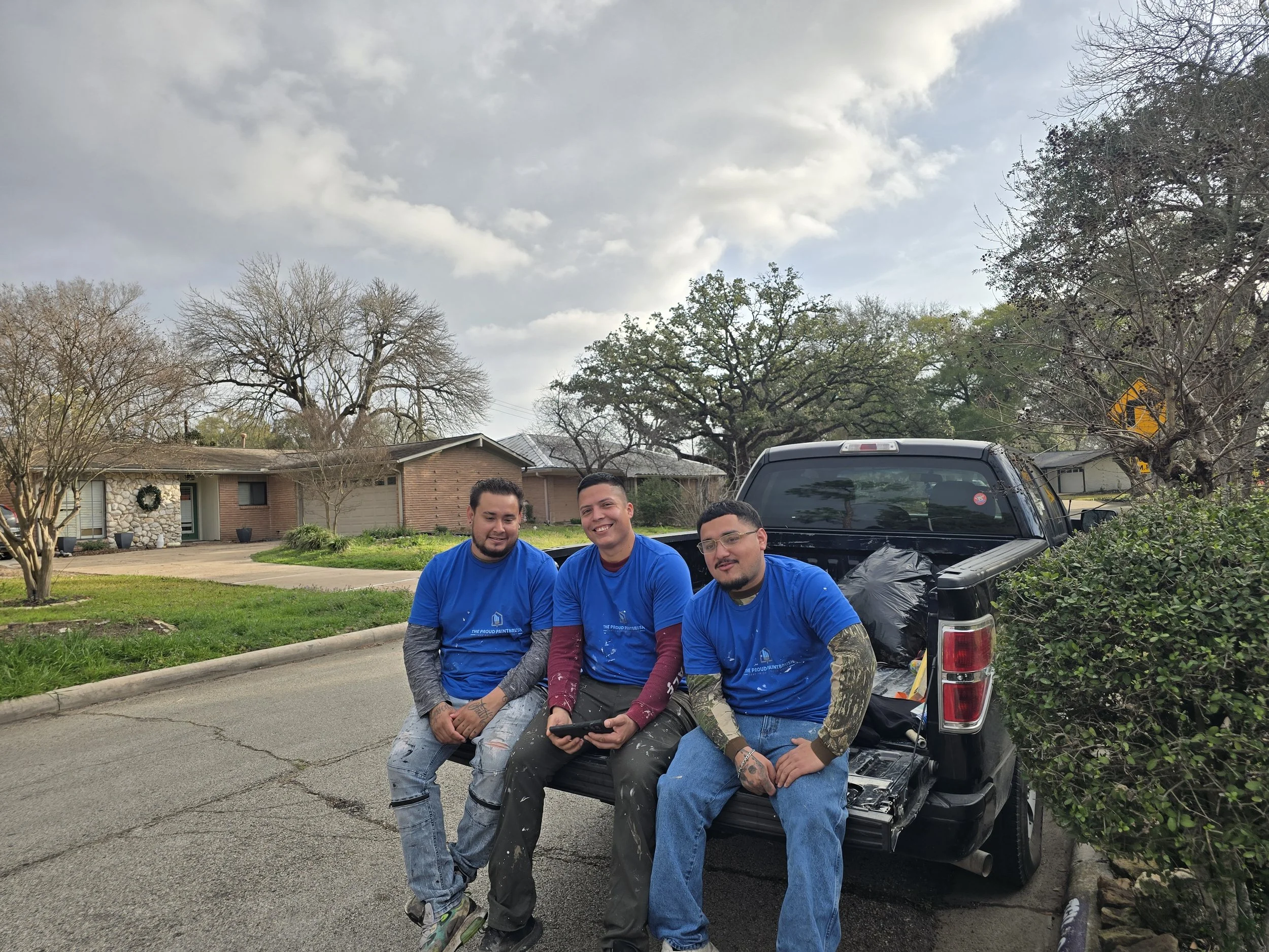 Three professional painters outside a home during Paint It Forward 2026 in West Houston, Texas.