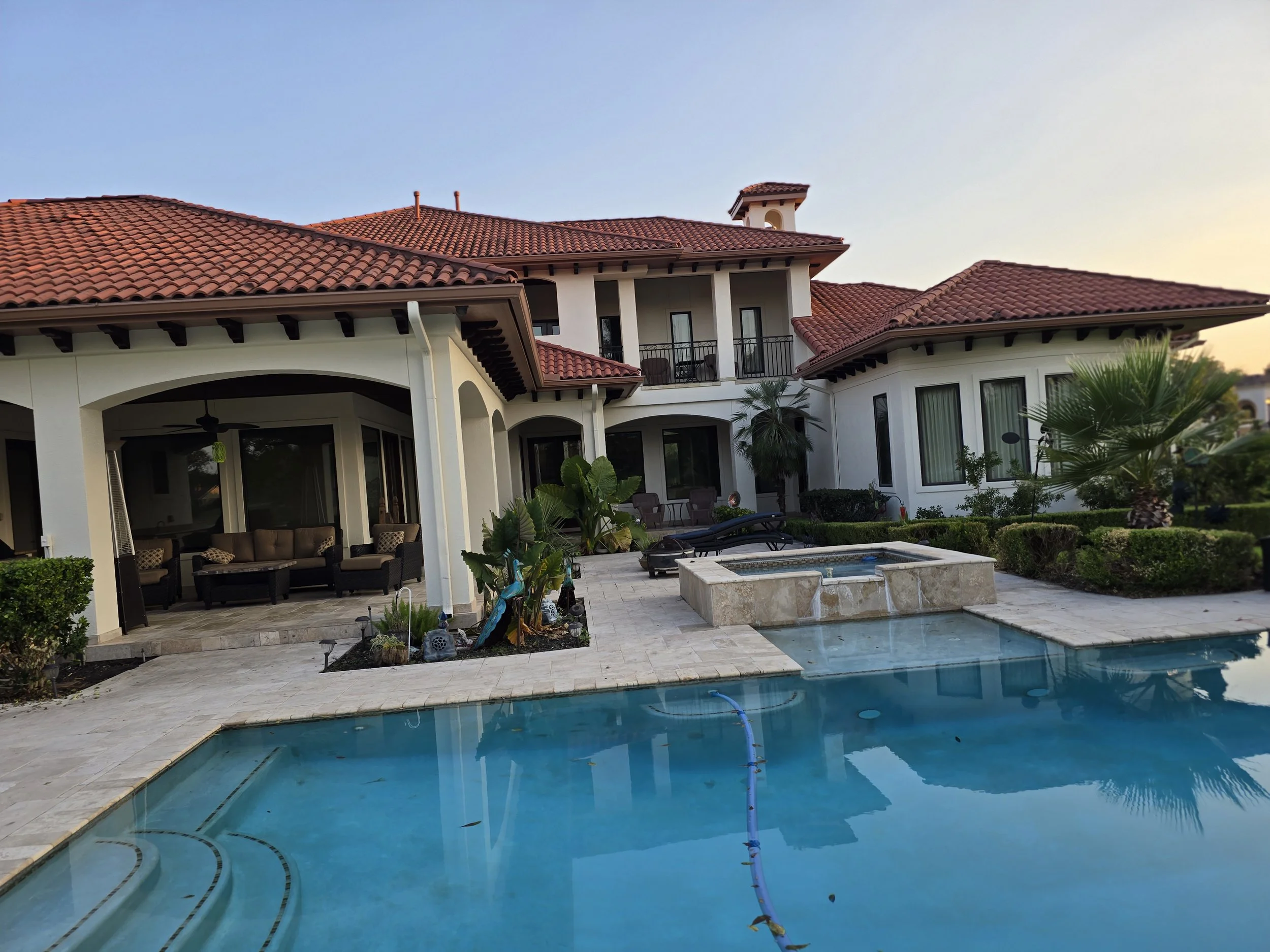 Exterior house painting for a luxury Sugar Land home featuring stucco walls, tile roof, and outdoor living space