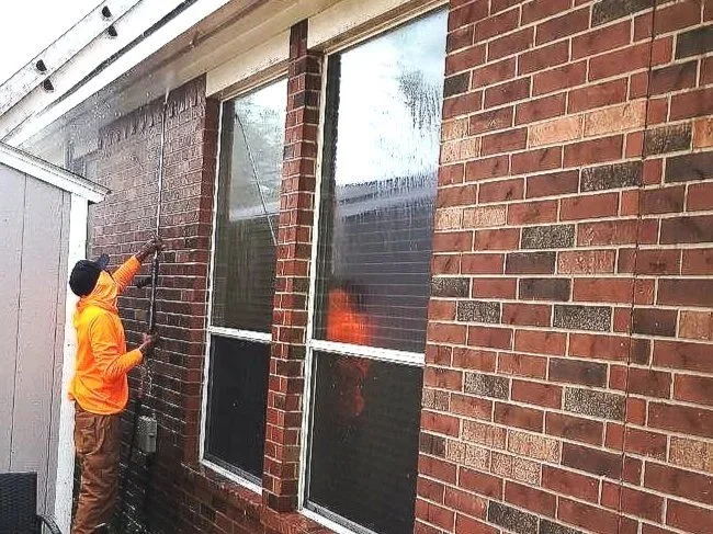 Pressure washer cleaning a wood fence to prepare it for painting in Katy, Texas.