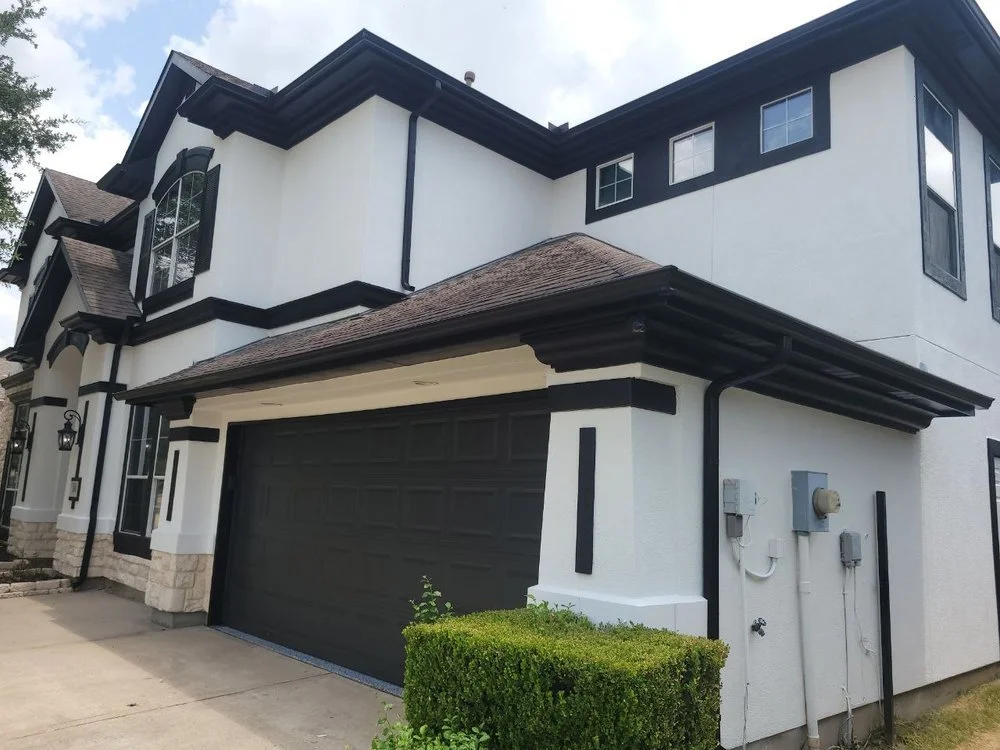Freshly painted white and black stucco house exterior in Richmond, Texas.