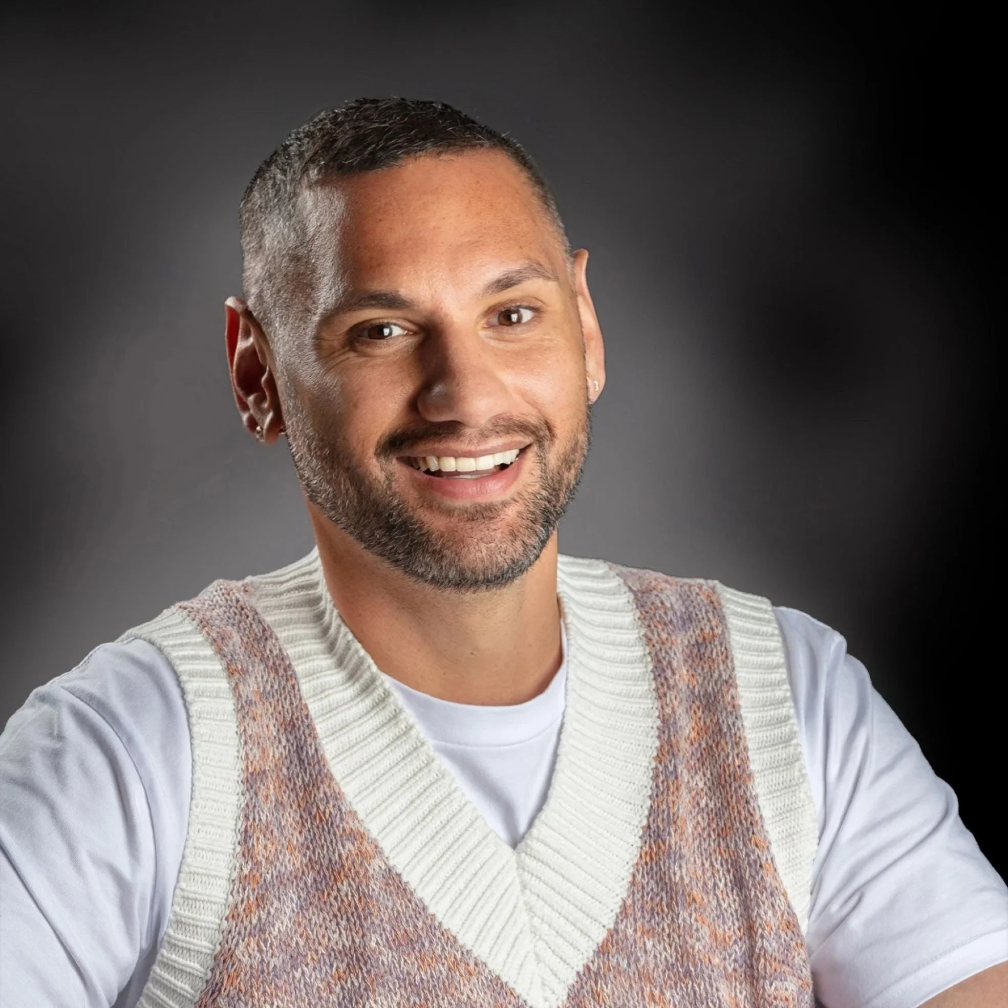 A photo of Bryan smiling, with a black background