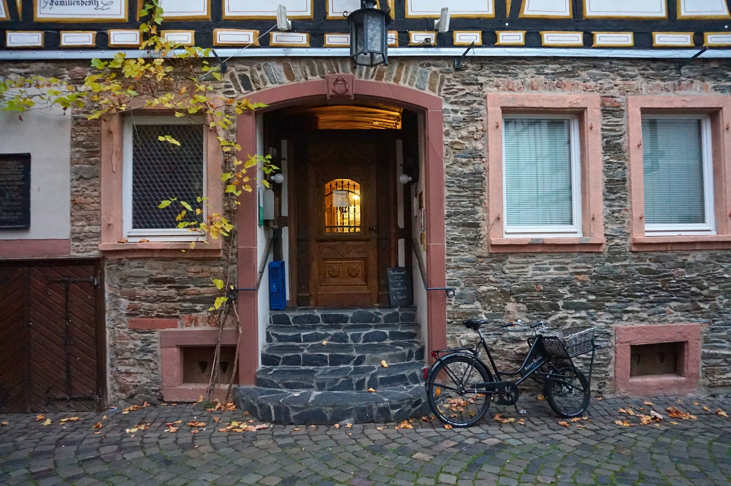 Stone house in Bacharach with ivy and a bike by the front stairs