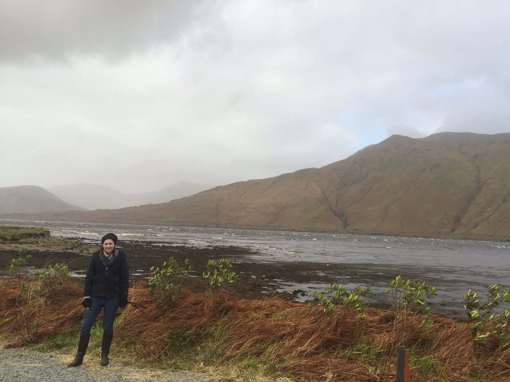 The author by the a lake in the Connemara region with large mountain behind her