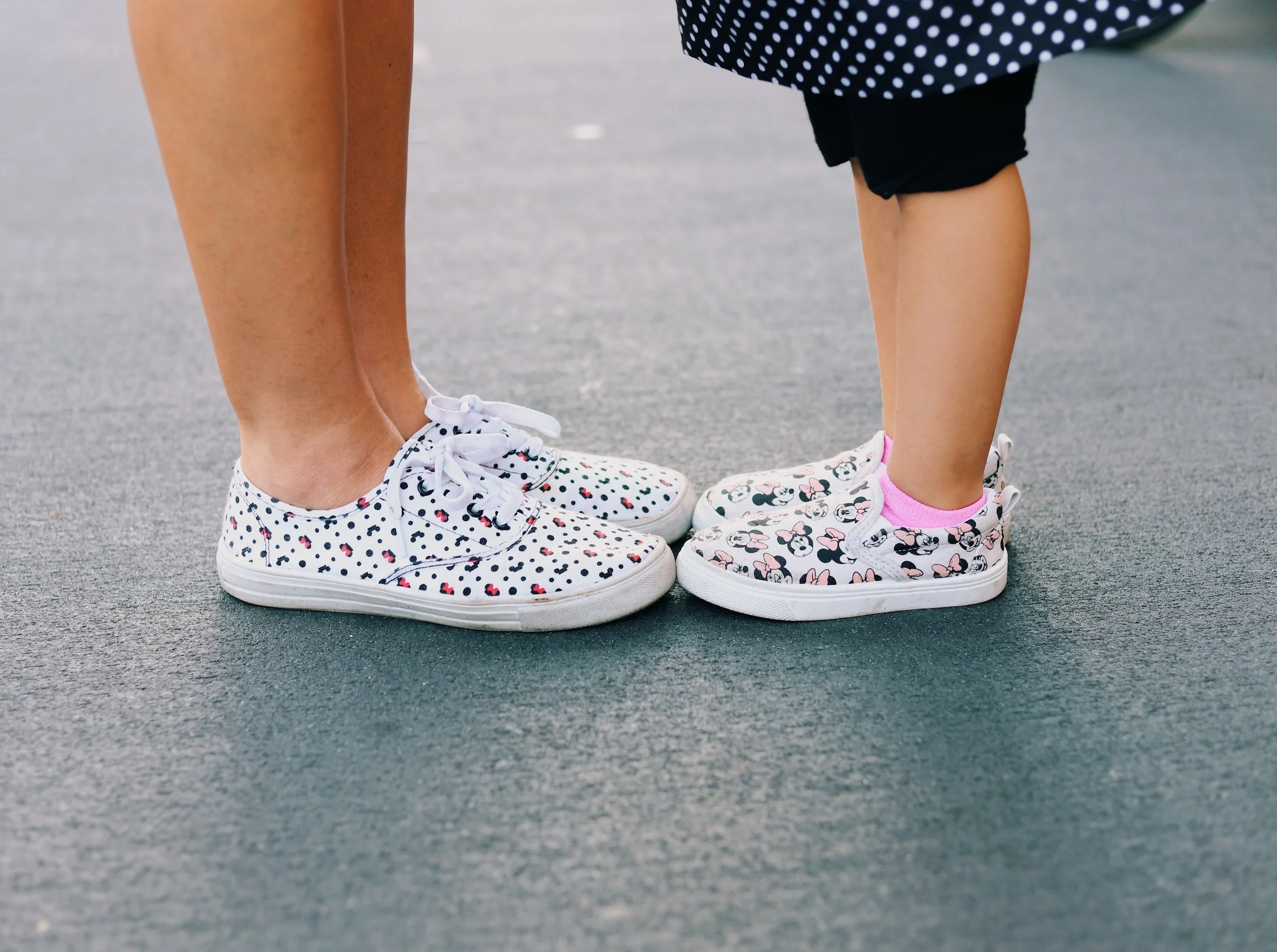 Mom and daughter stand toe-to-toe with matching Minnie Mouse shoes on