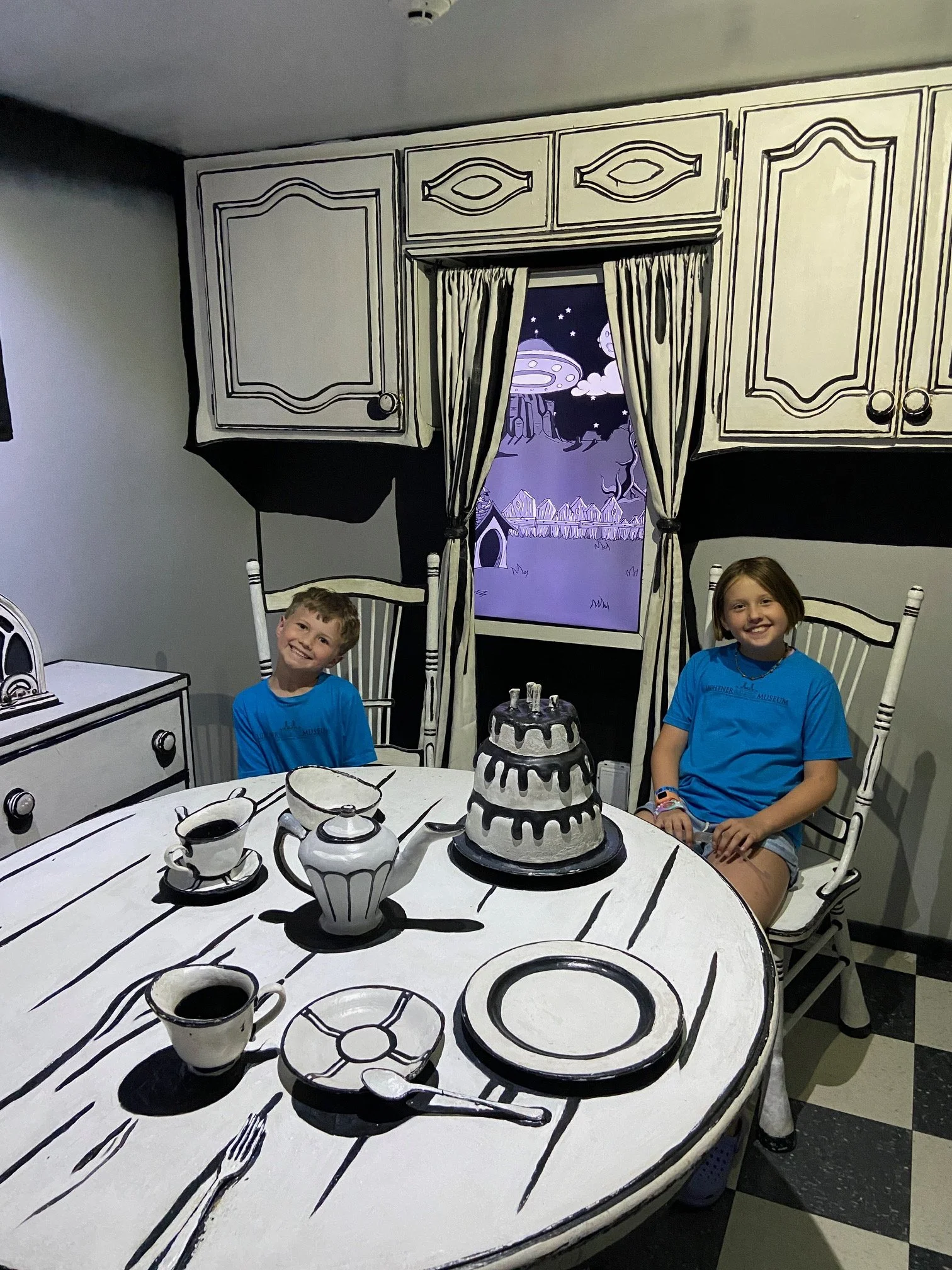 The author's children sit down in a room that looks like it's from a black and white sketch drawing