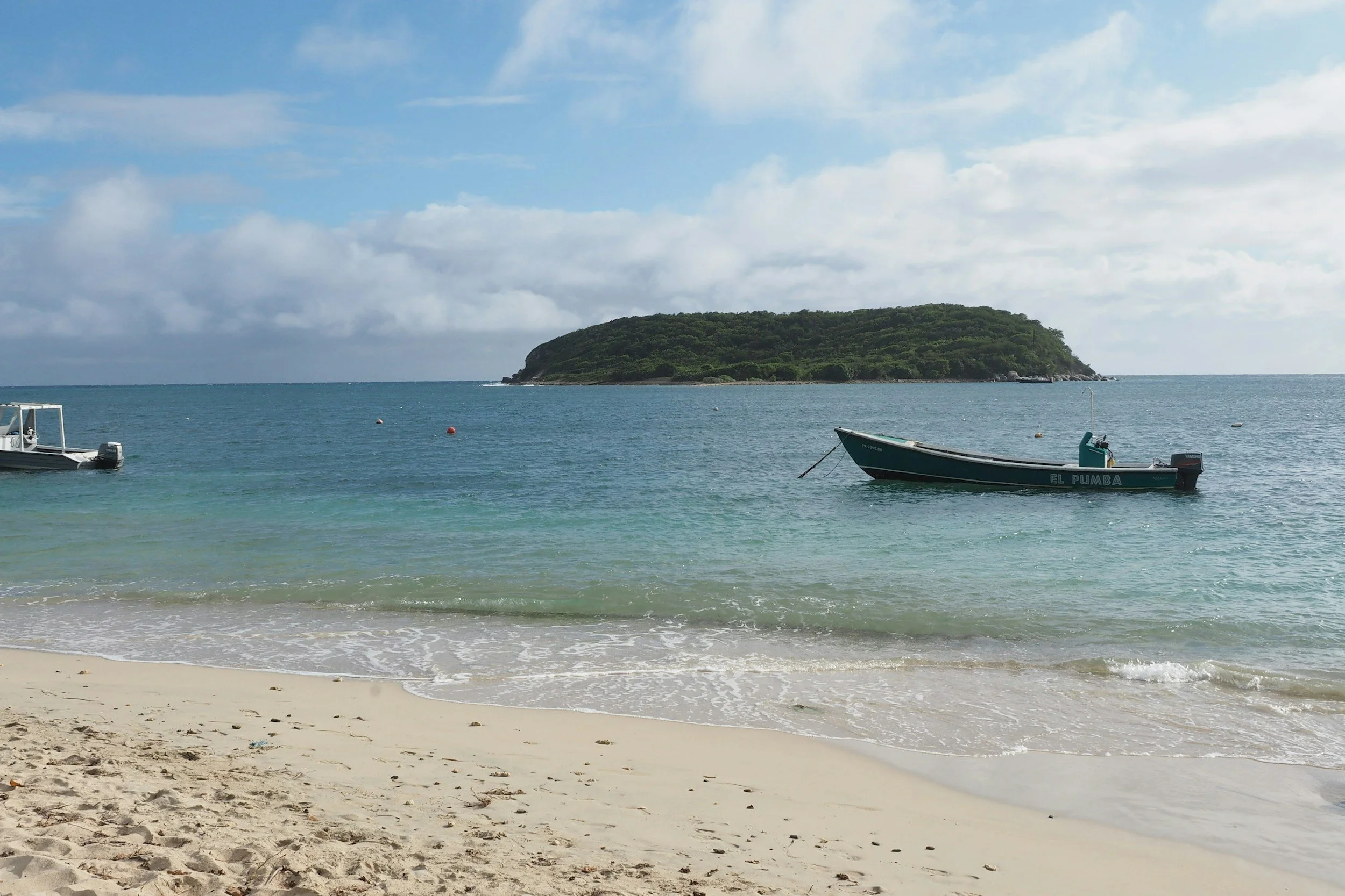 Small boats are anchored near the sandy beach on Vieques