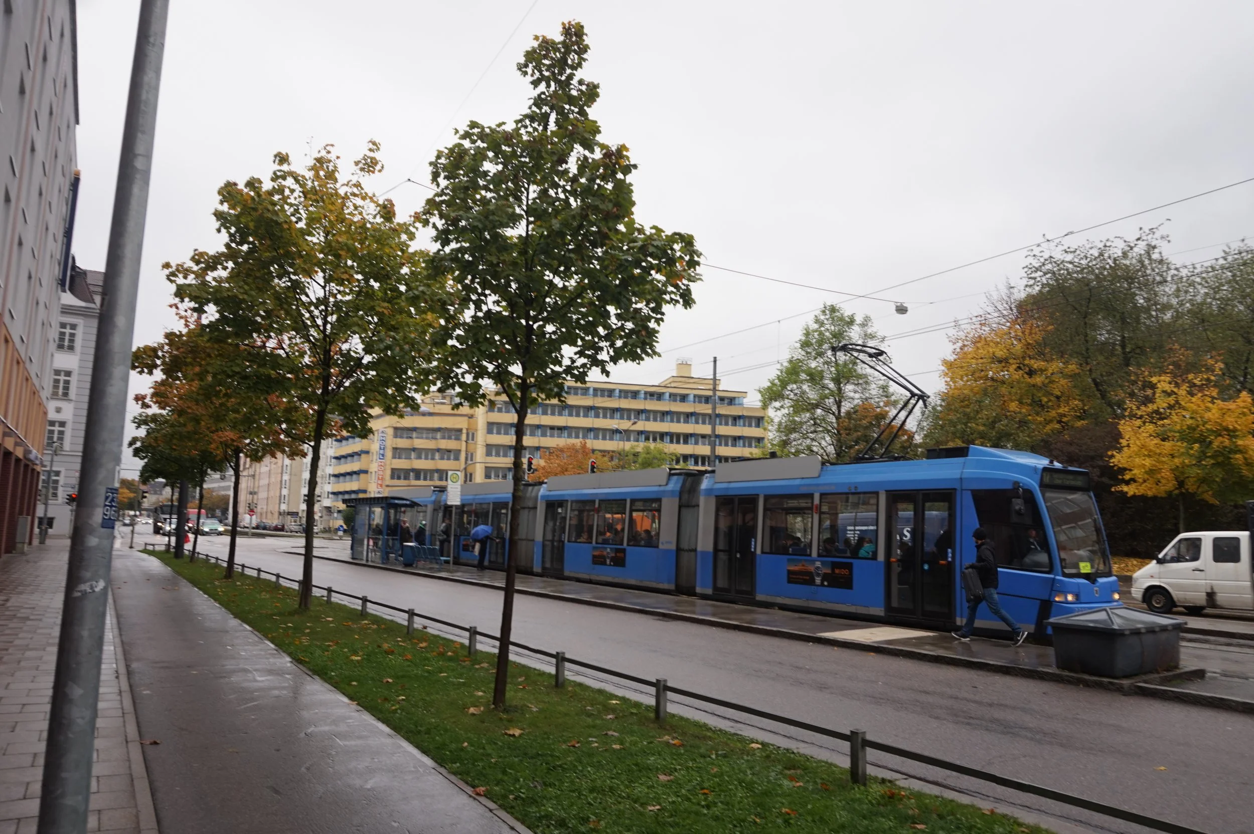 Blue electric tram picks up passengers in Munich, Germany