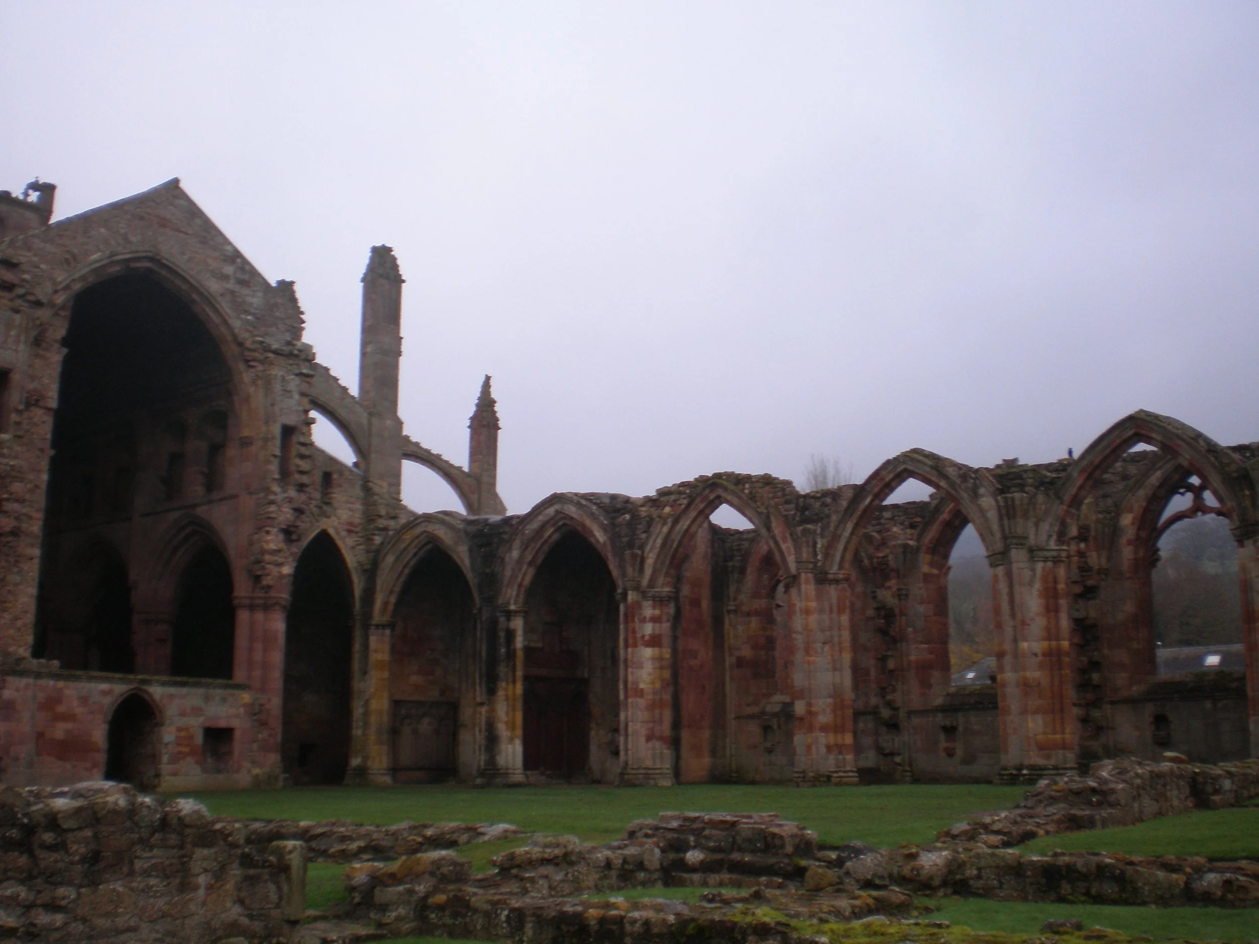 The ruins of the abbey are seen with the largest covered area remaining to the left of the photo