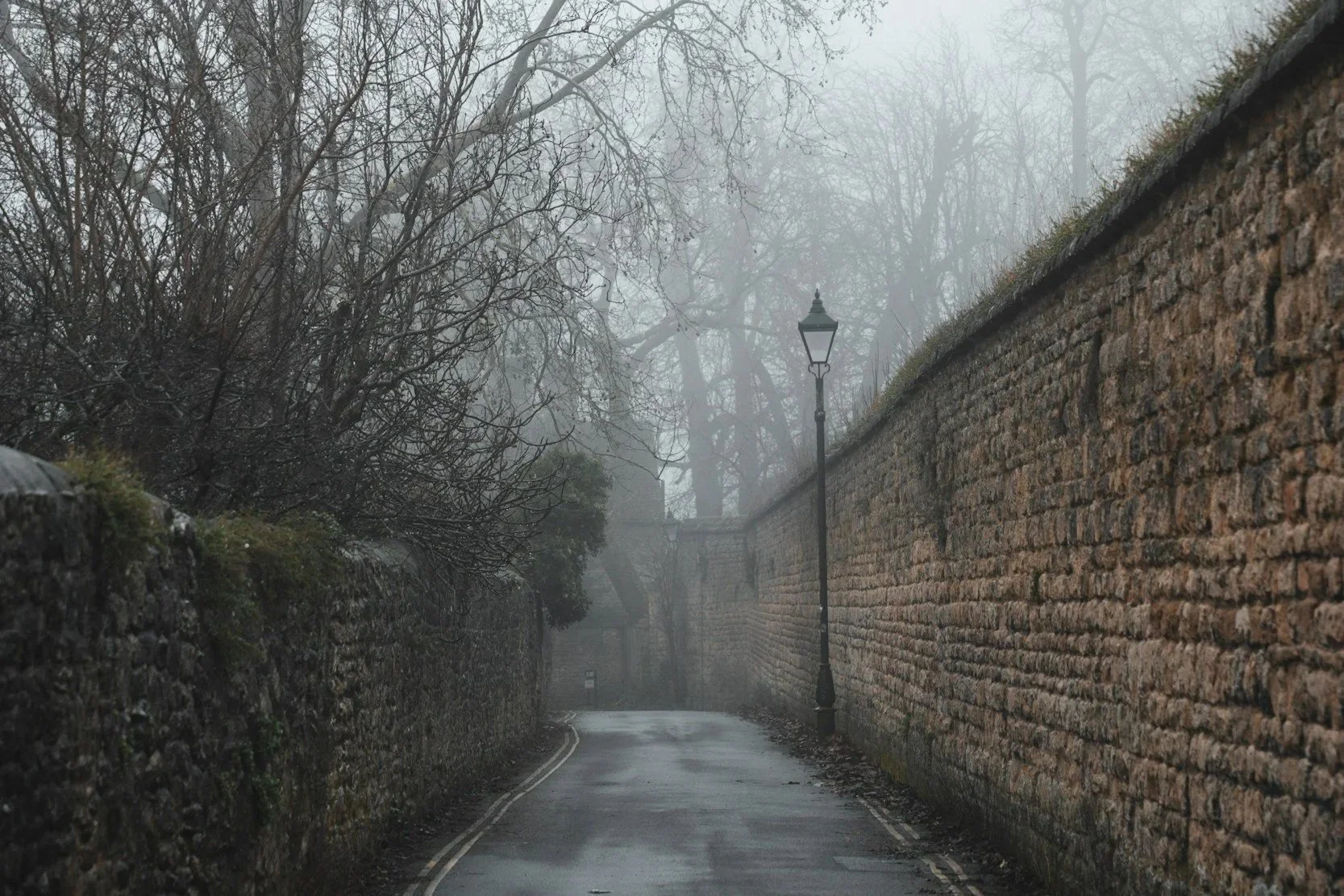 Foggy road in London with stone walls on either side