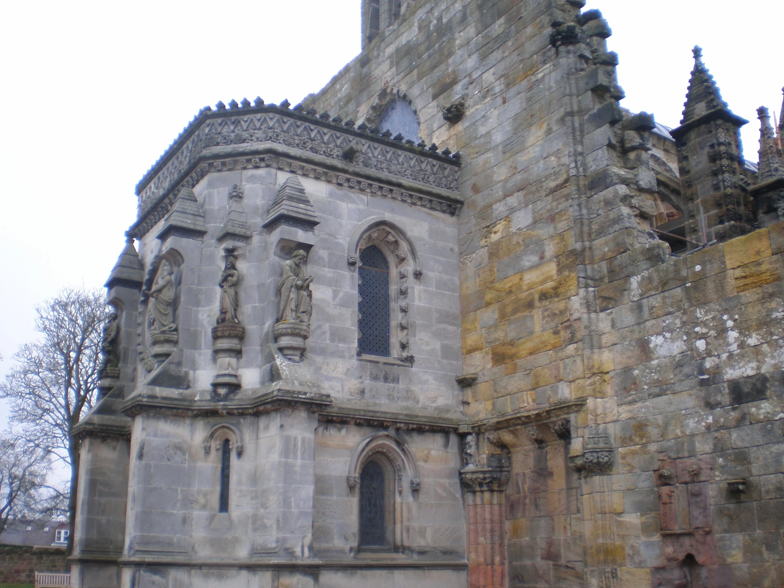 Stone exterior of Rosslyn Chapel with statues and columns as decoration