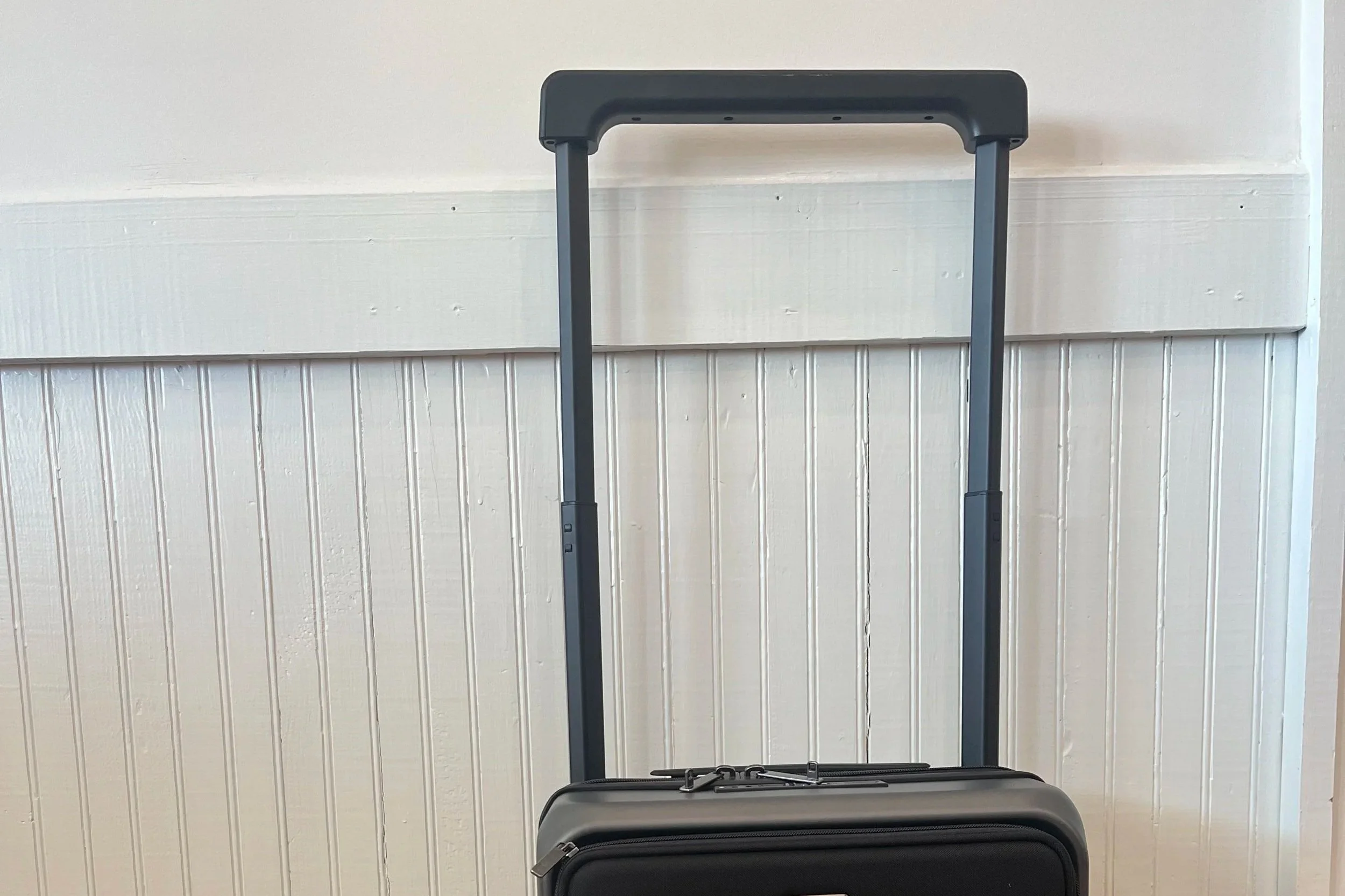 The handle of the suitcase is opened fully