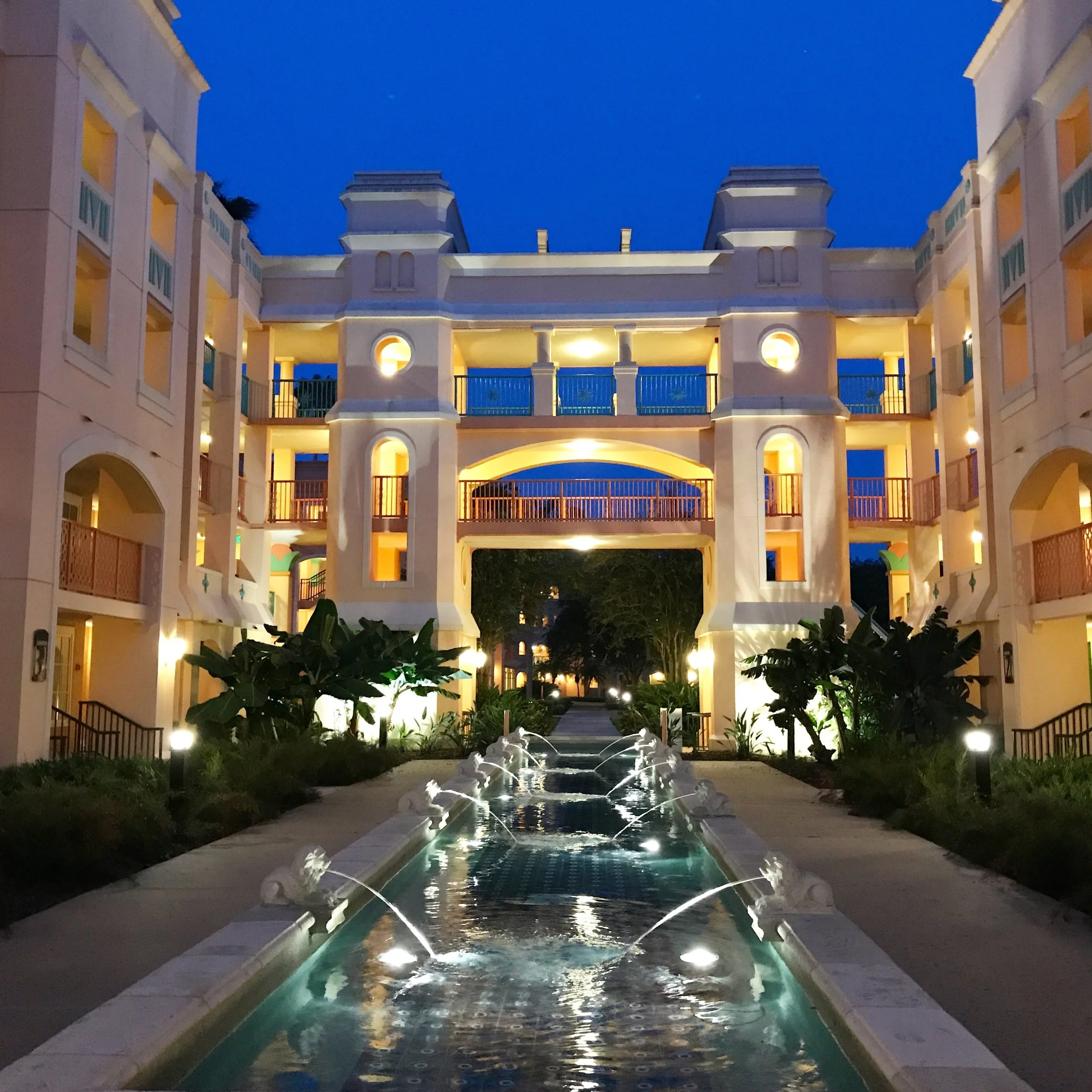 Fountain and hotel corridors lit up at night at Coronado Springs Resort