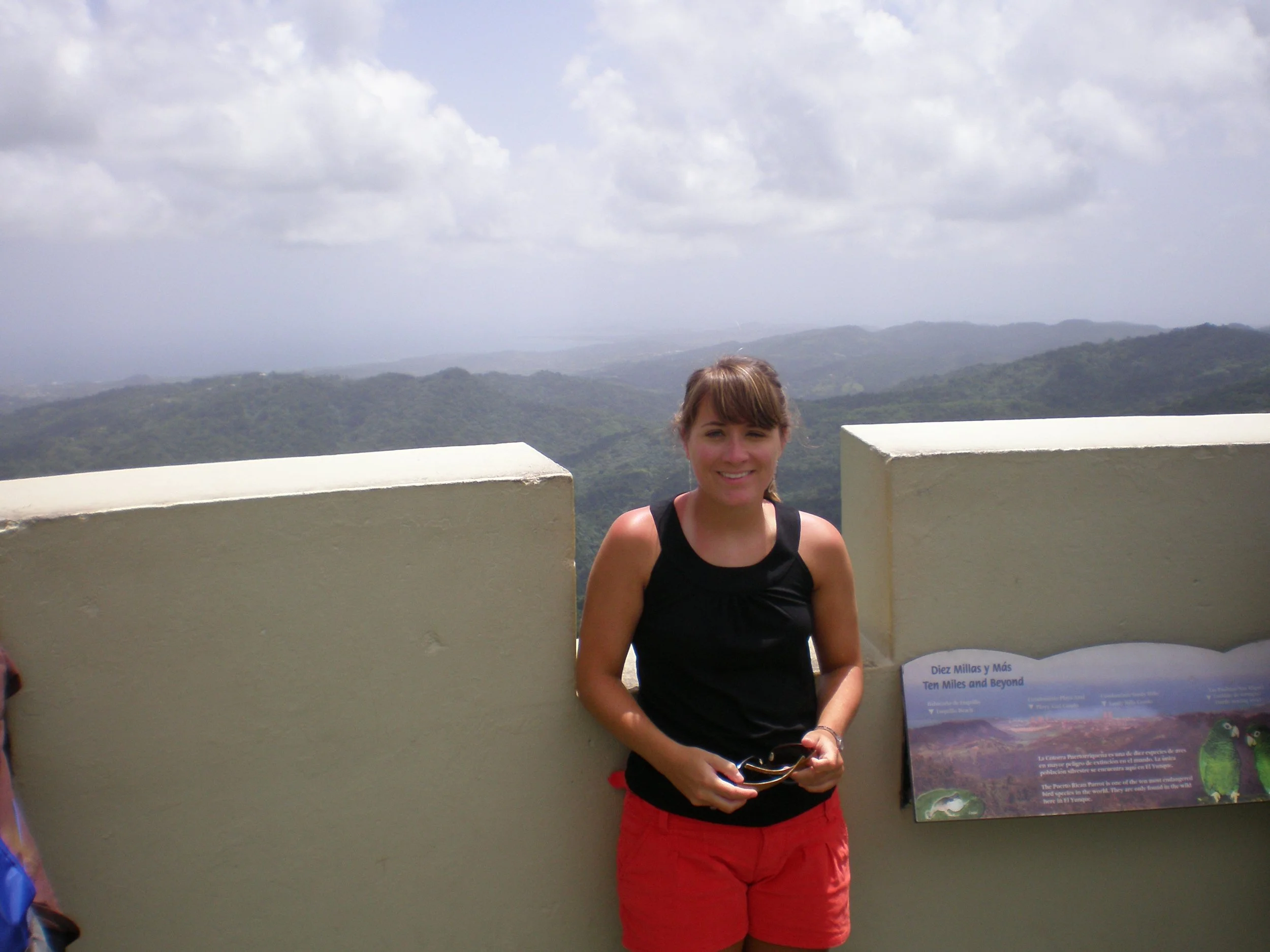 The author's sister standing at the top of Los Picachos Tower with the rainforest beyond