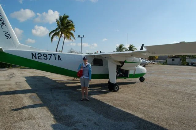 The author standing next to a small plane at San Andros airport