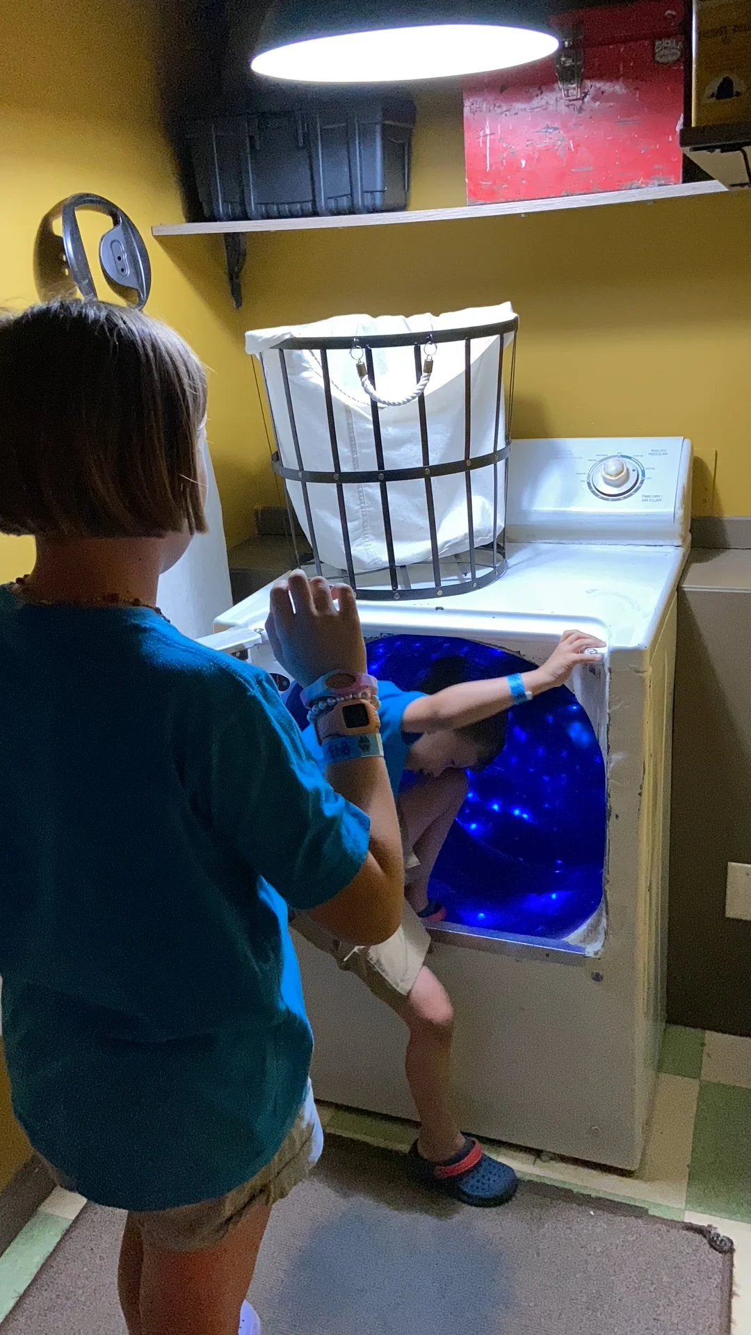 The author's son prepares to slide through the dryer in the Meow Wolf farmhouse laundry room