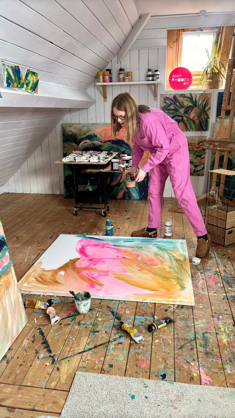 British contemporary painter, Amy Rhodes painting her in home studio, south staffordshire.