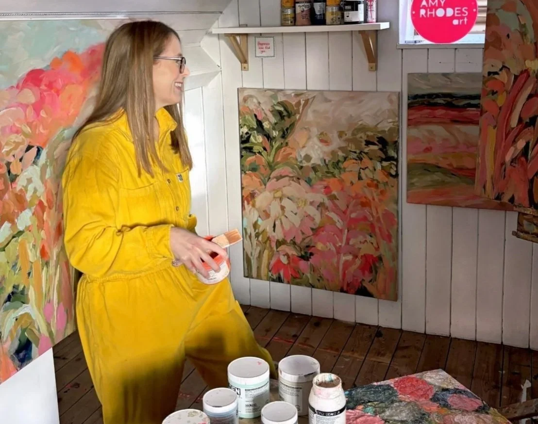 British artist Amy Rhodes in her South Staffordshire studio with her vibrant abstract floral paintings.