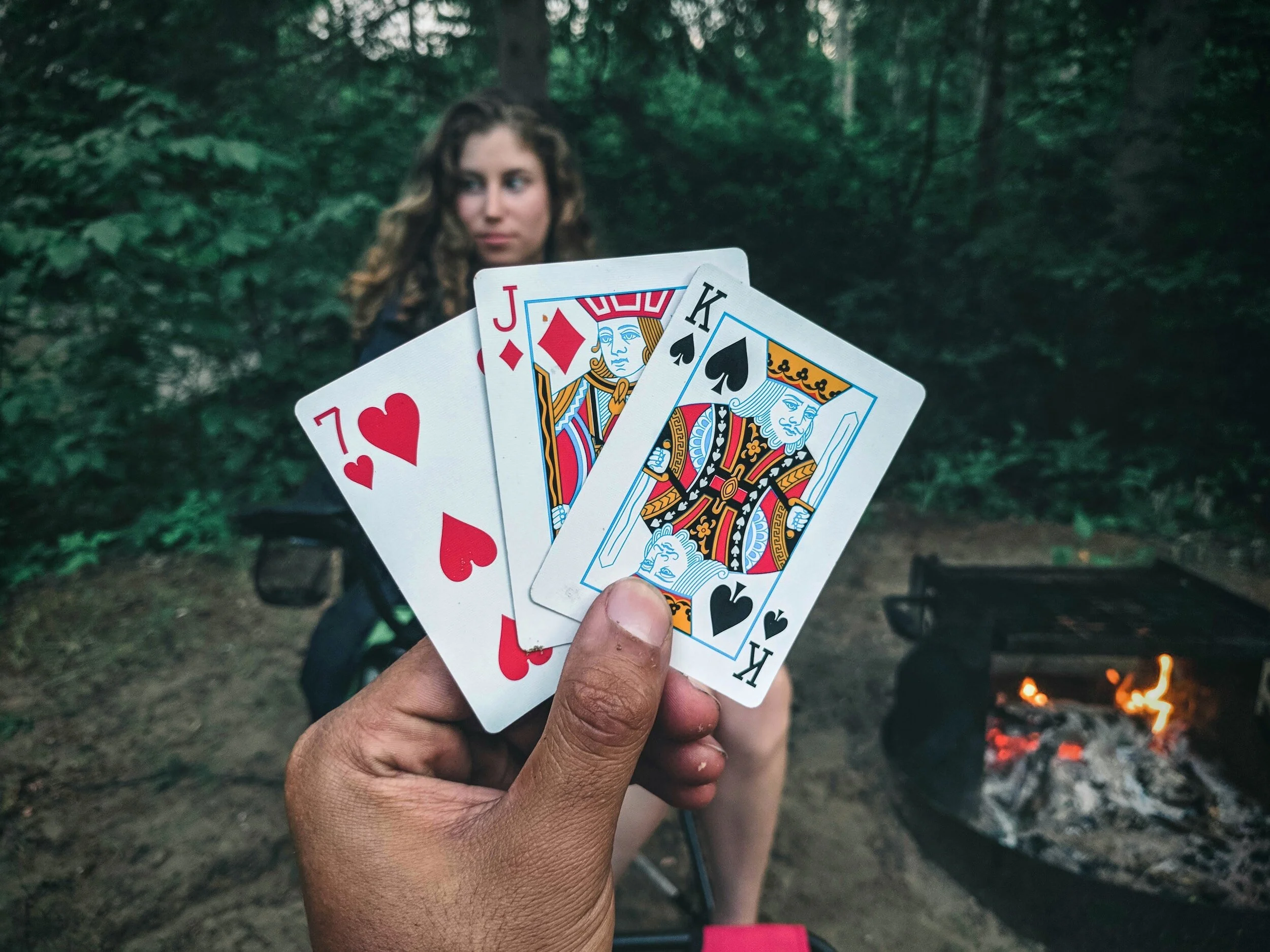 Person holding playing cards in a forest, illustrating the importance of using your unique strengths.